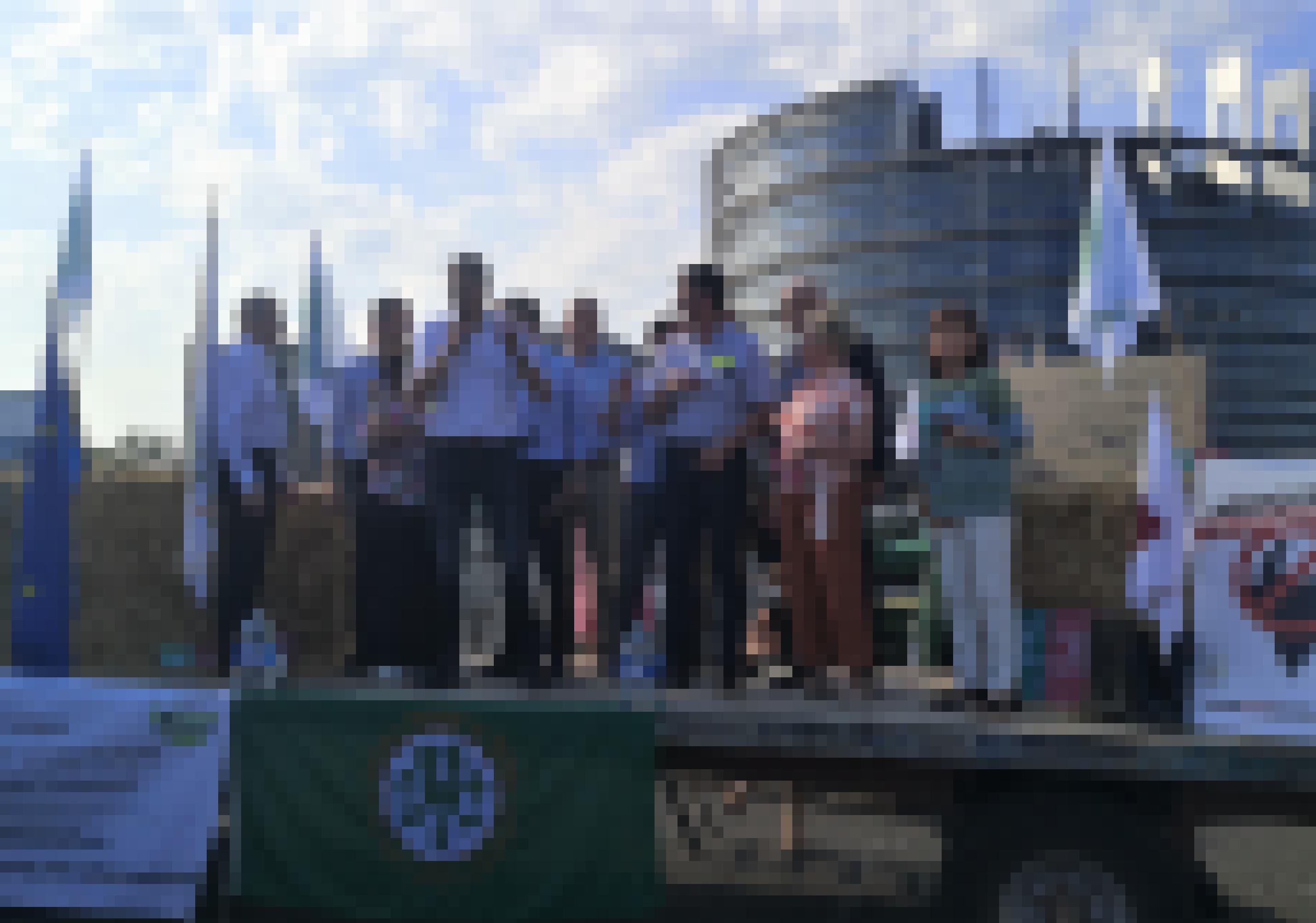 Ein Dutzend Menschen auf einem Traktoranhänger vor dem EU-Parlament