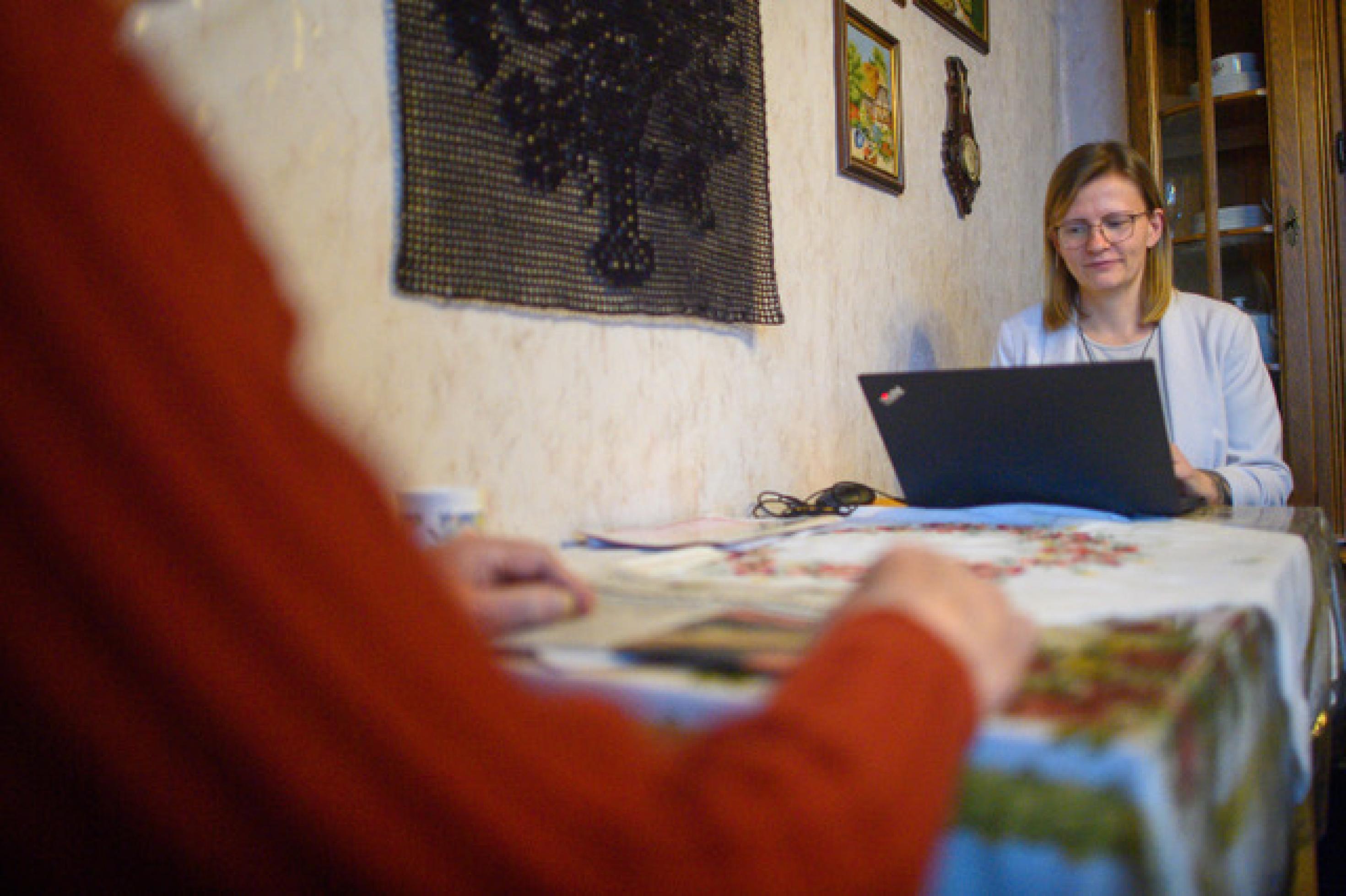 Eine Gutachterin sitzt mit Laptop am Tisch, ihr gegenüber ein alter Mensch. Beim Begutachtungstermin zur Feststellung der Pflegebedürftigkeit entscheidet sich, ob ein Mensch Geld von der Pflegeversicherung bekommt.