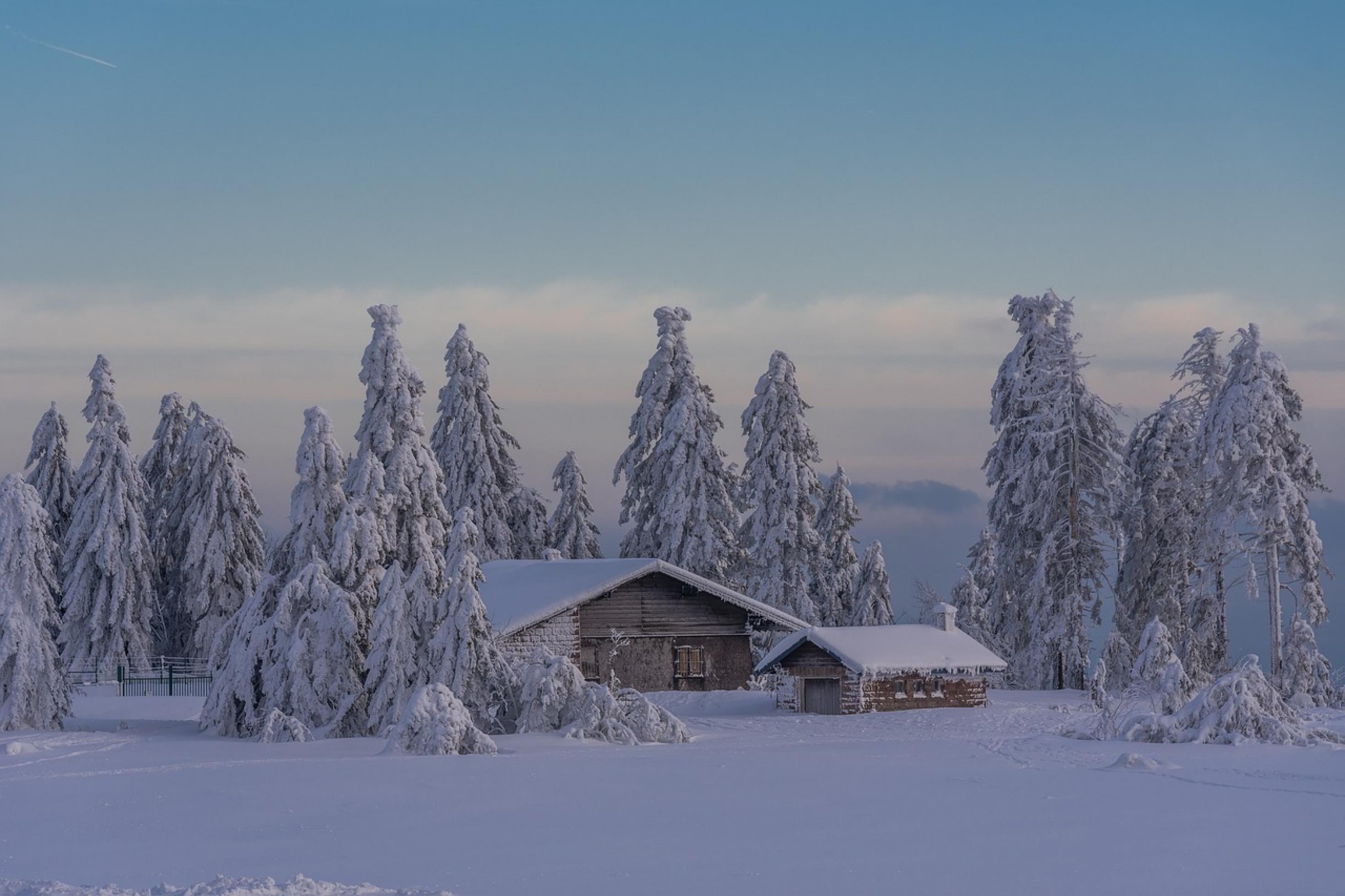 Schneebedecktes Dach eines Ziegelhauses in warmem Abendlicht
