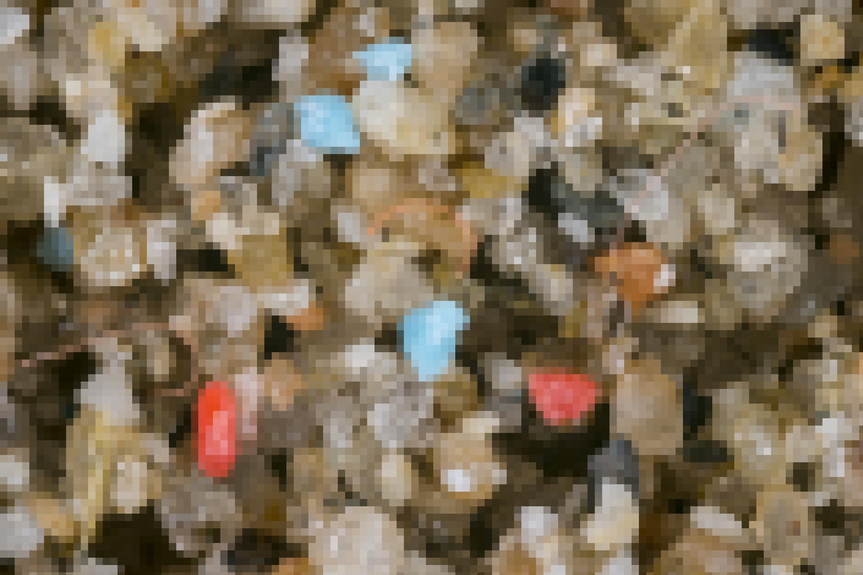 Kleinste Plastikteile zwischen Sandkörnern.