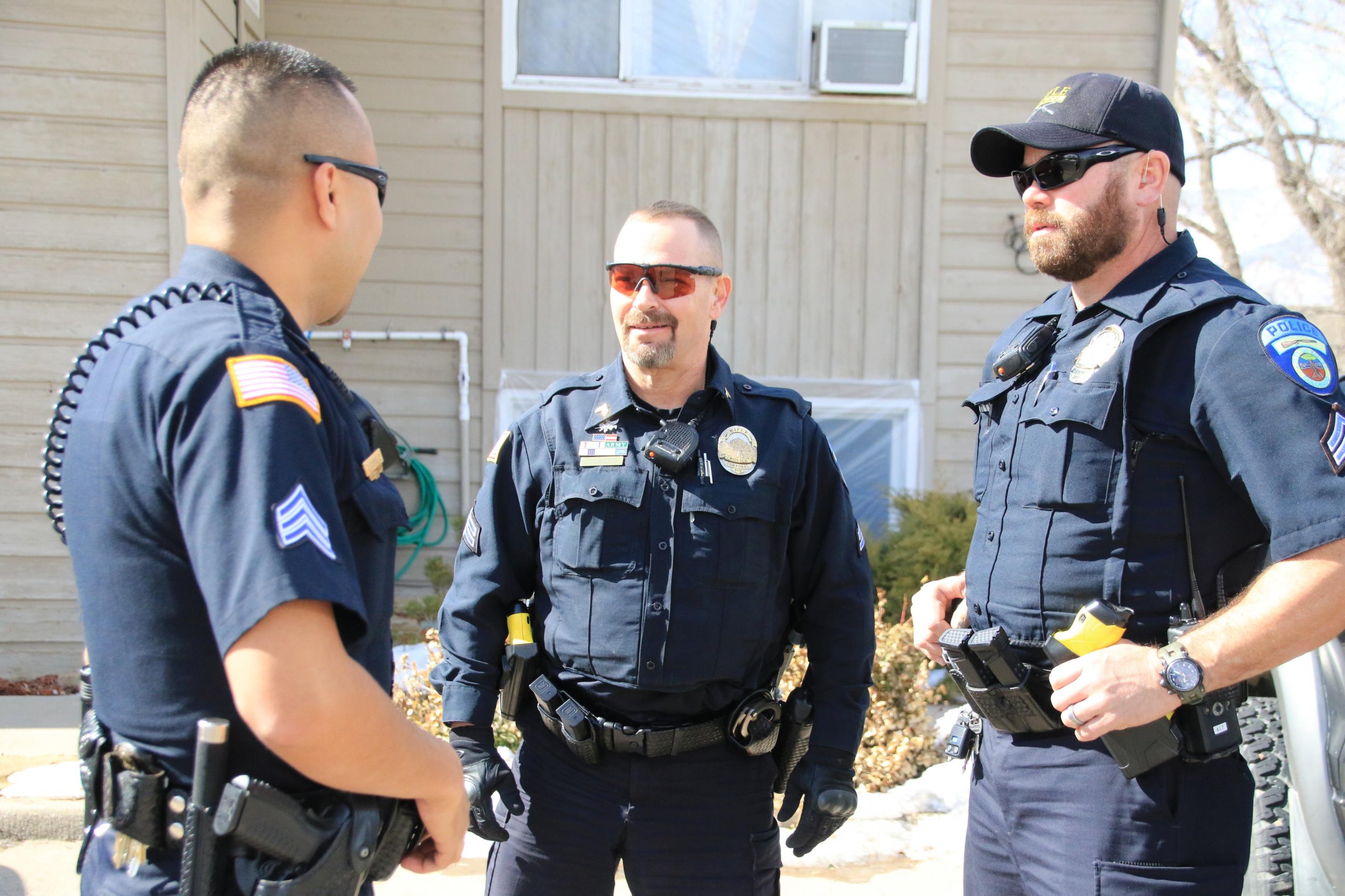 Drei Polizisten stehen nebeneinander und reden