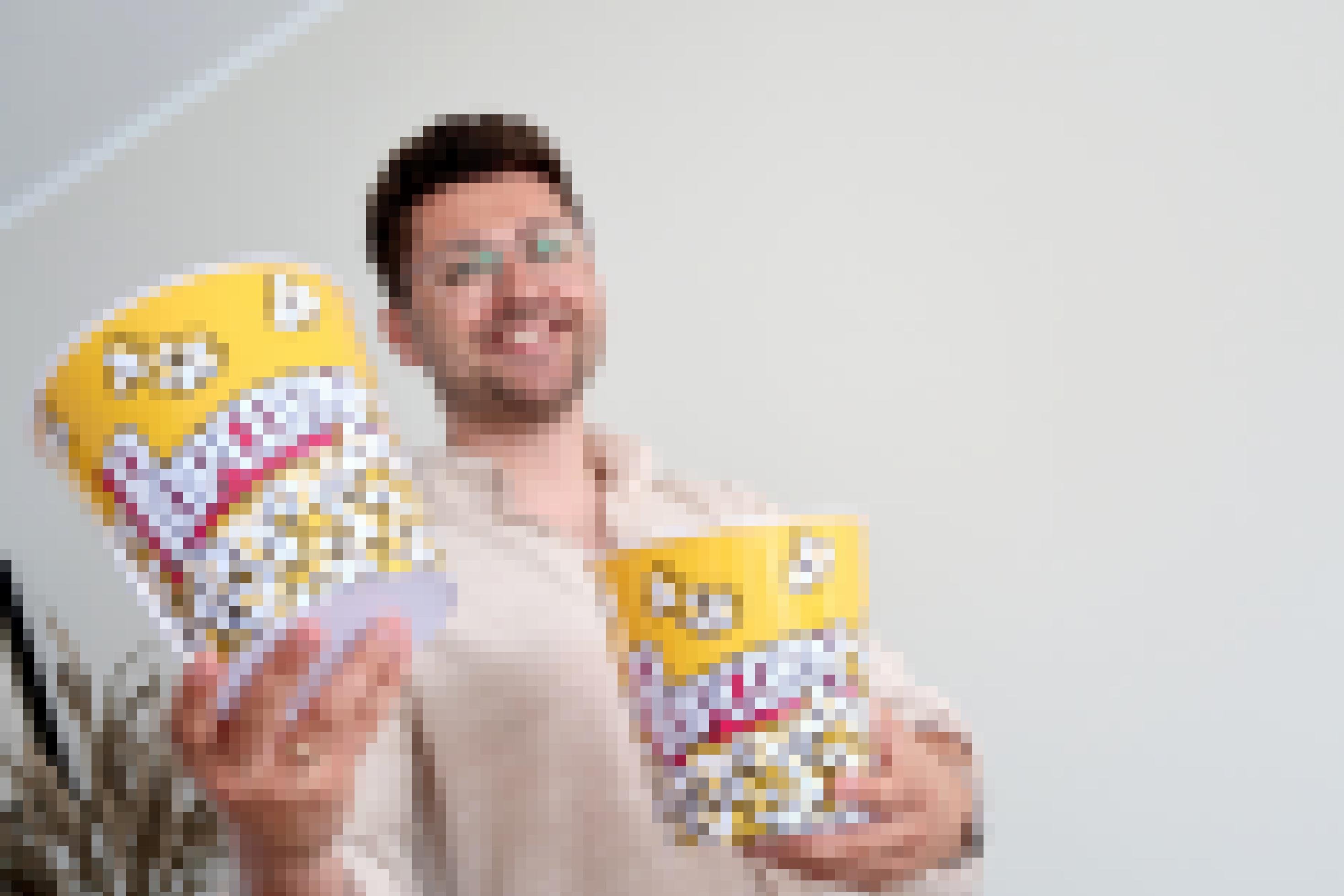 Benedikt Leder hält zwei Popcorn-Eimer in den Händen.