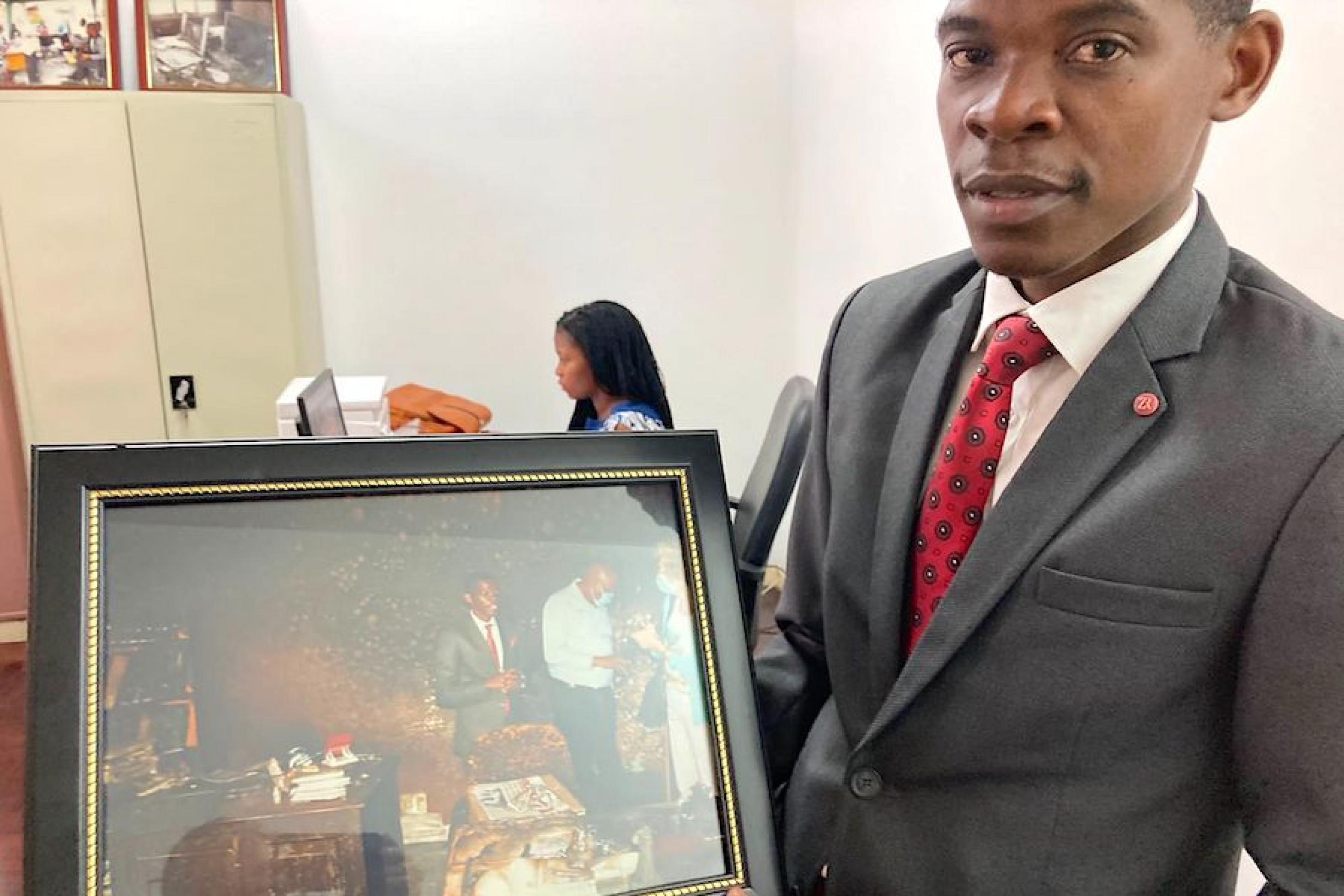 Matias Guente, Chefredakteur der regierungskritischen Zeitung „Canal de Moçambique“, zeigt ein Foto von 2021, auf dem zu sehen ist, wie ihm der International Press Freedom Award verliehen wird.