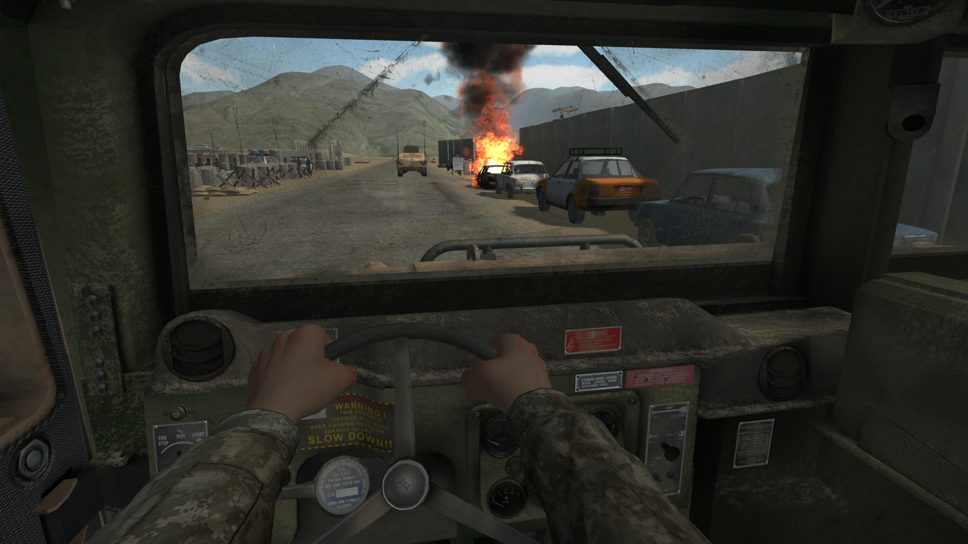 Simulation einer Kriegsszene im Computer: Man blickt aus der Ich-Perspektive hinaus aus einem Militärfahrzeug auf eine staubige Straße eines afghanischen Dorfes.. Am rechten Fahrbahnrand parken mehrere alte Autos. Eines davon brennt lichterloh. Im Hintergrund ragen mehrere Berge über das triste Landschaftsbild empor.