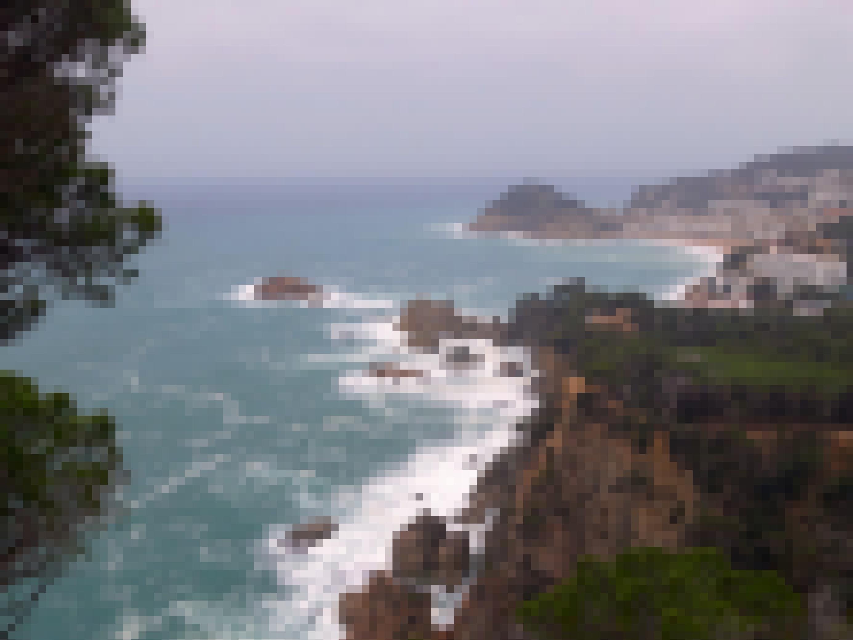 Tiefblick auf das schäumende Meer der Costa Brava, die an dieser Stelle vorgelagerte Klippen besitzt.