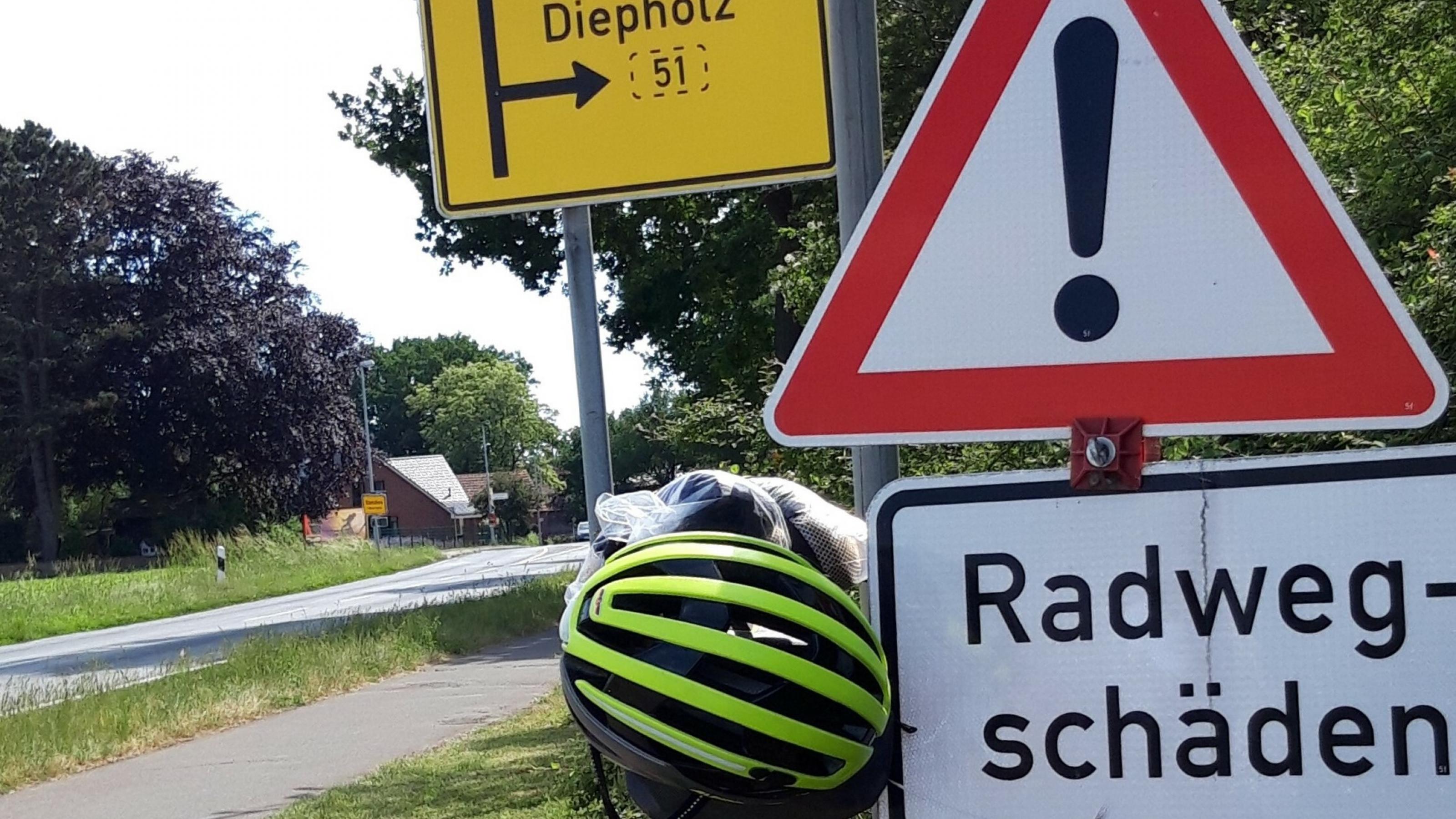 Neben dem Radweg nördlich von Lübbecke prangt ein Warnschild mit der Aufschrift „Radwege-Schäden“.