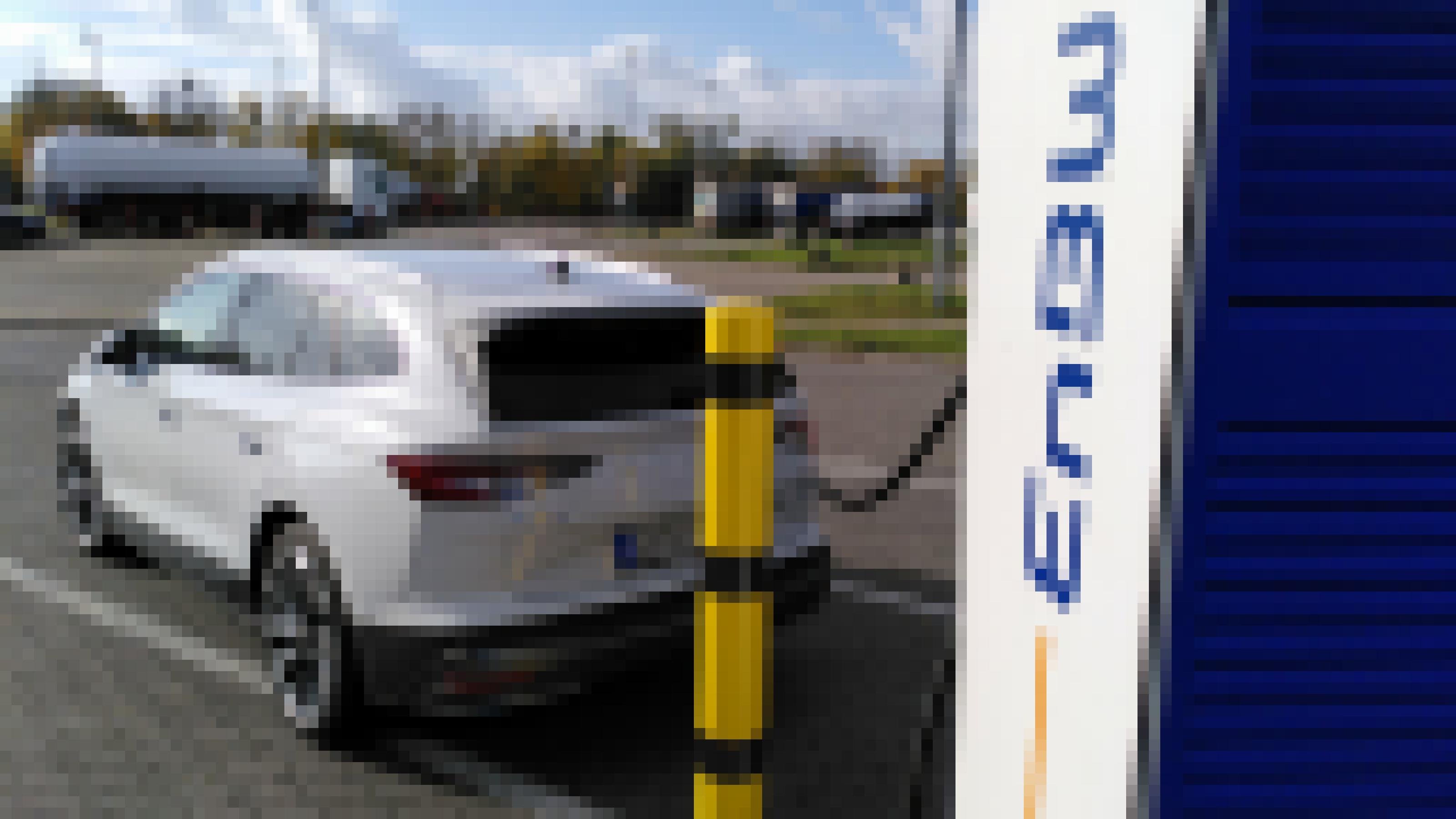 Ein Elektroauto ist auf einem Autobahn-Parkplatz an eine Ladestation angeschlossen.