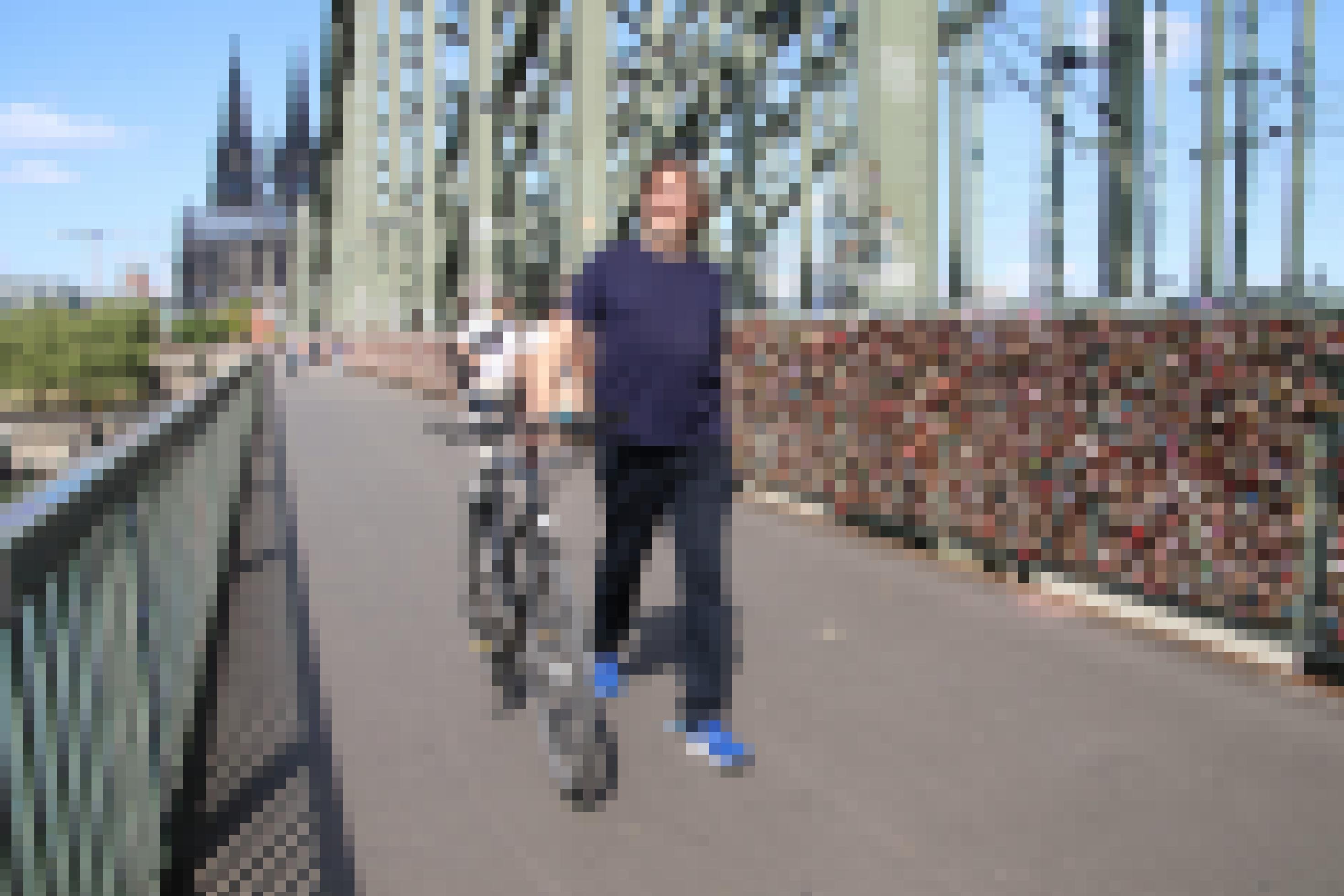 Reinhold Goss schiebt sein Fahrrad über eine Brücke.