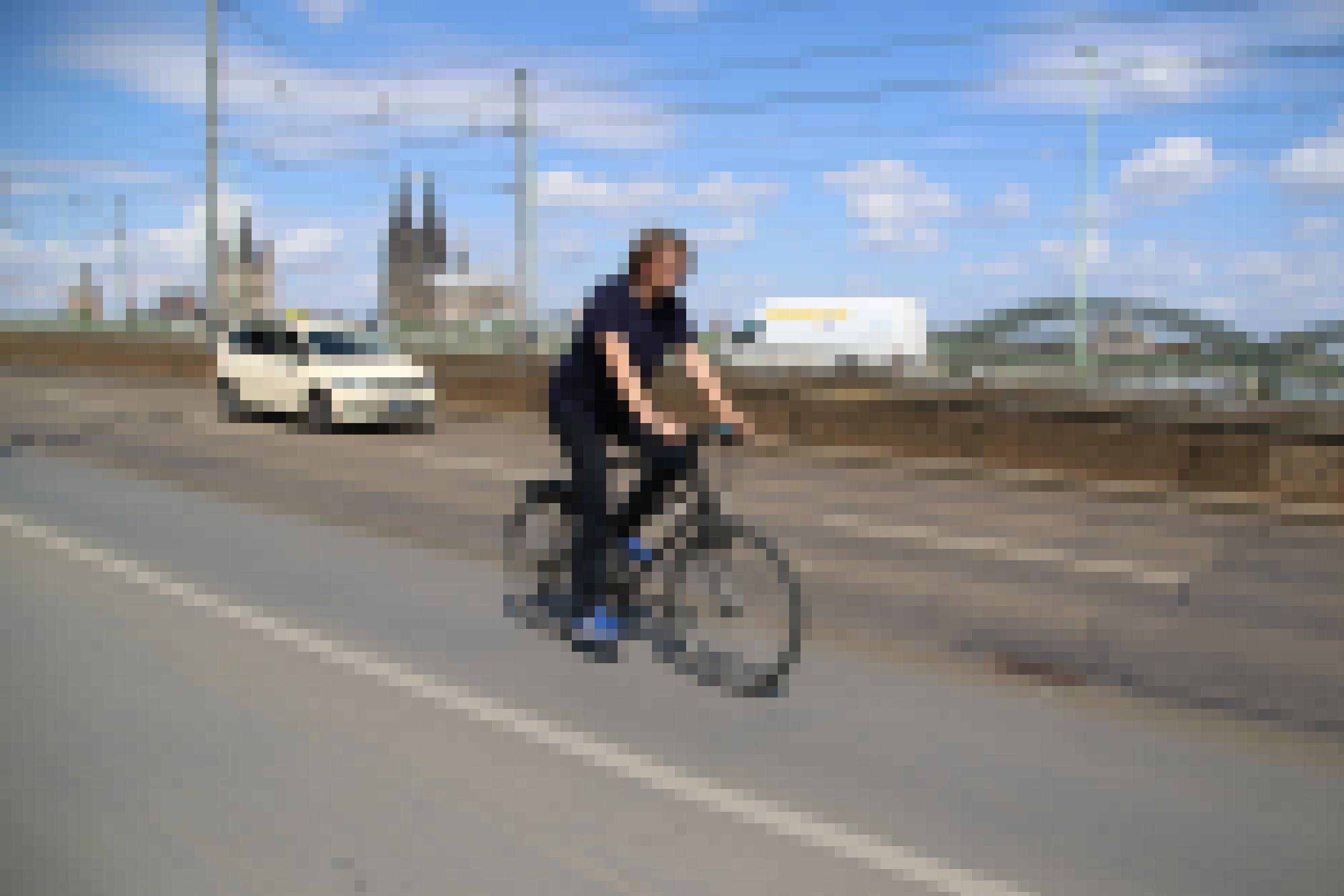 Reinhold Goss radelt über eine Brücke in Köln.