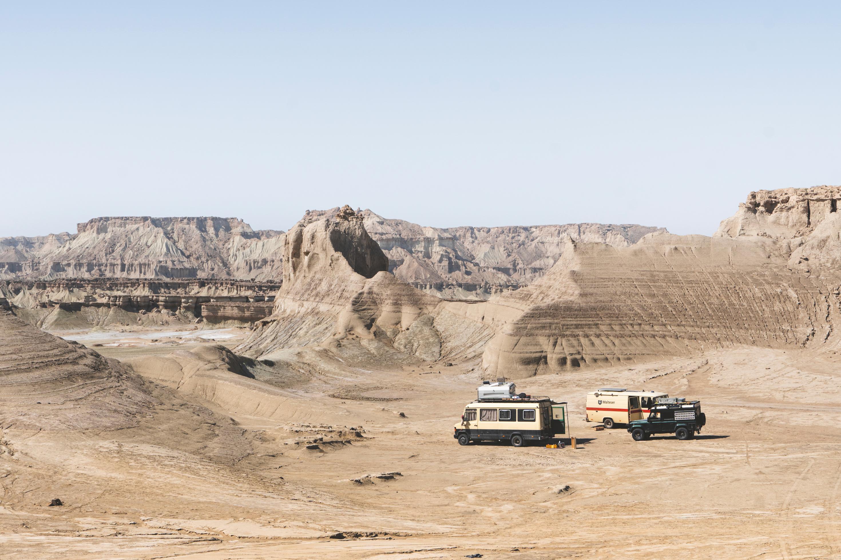 Zwei Van in einer gebirgigen Landschaft.