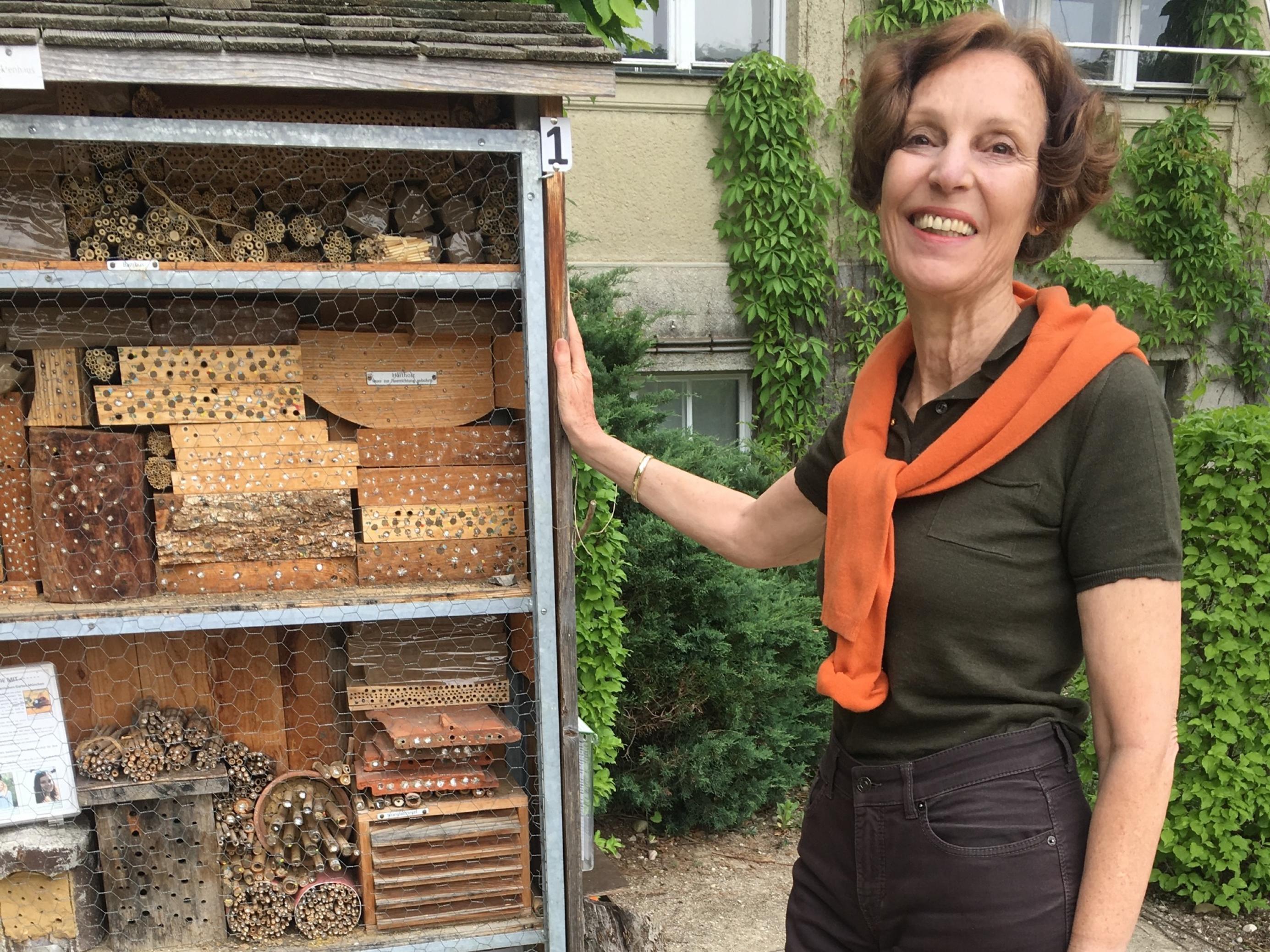 Susanne S. Renner steht neben einem Insektenhotel.