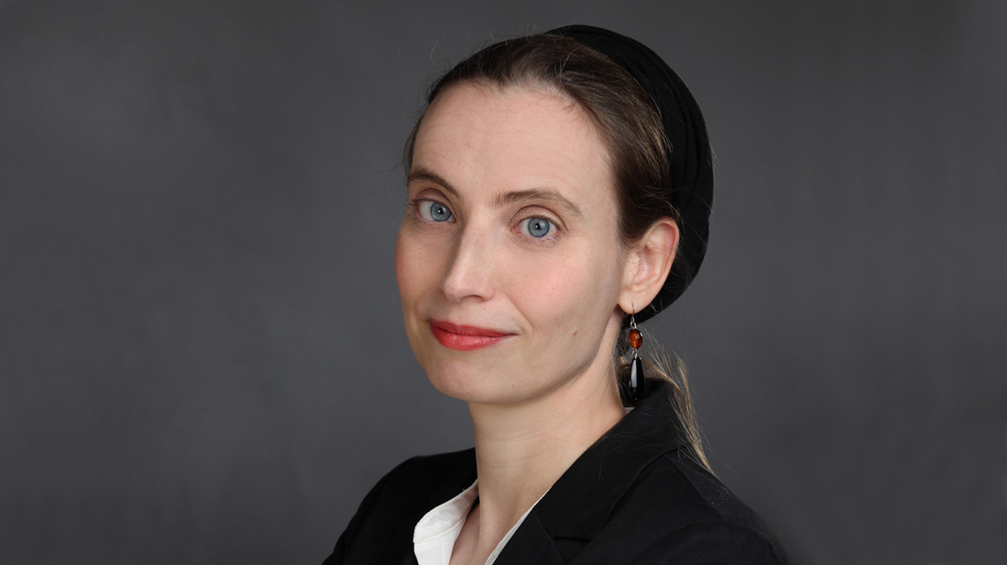 Portraitfoto der RiffReporterin Christiane Enkeler im Halbprofil: blonde Haare, blaue Augen, schwarzes Haarband, tropfenförmiger Ohrring