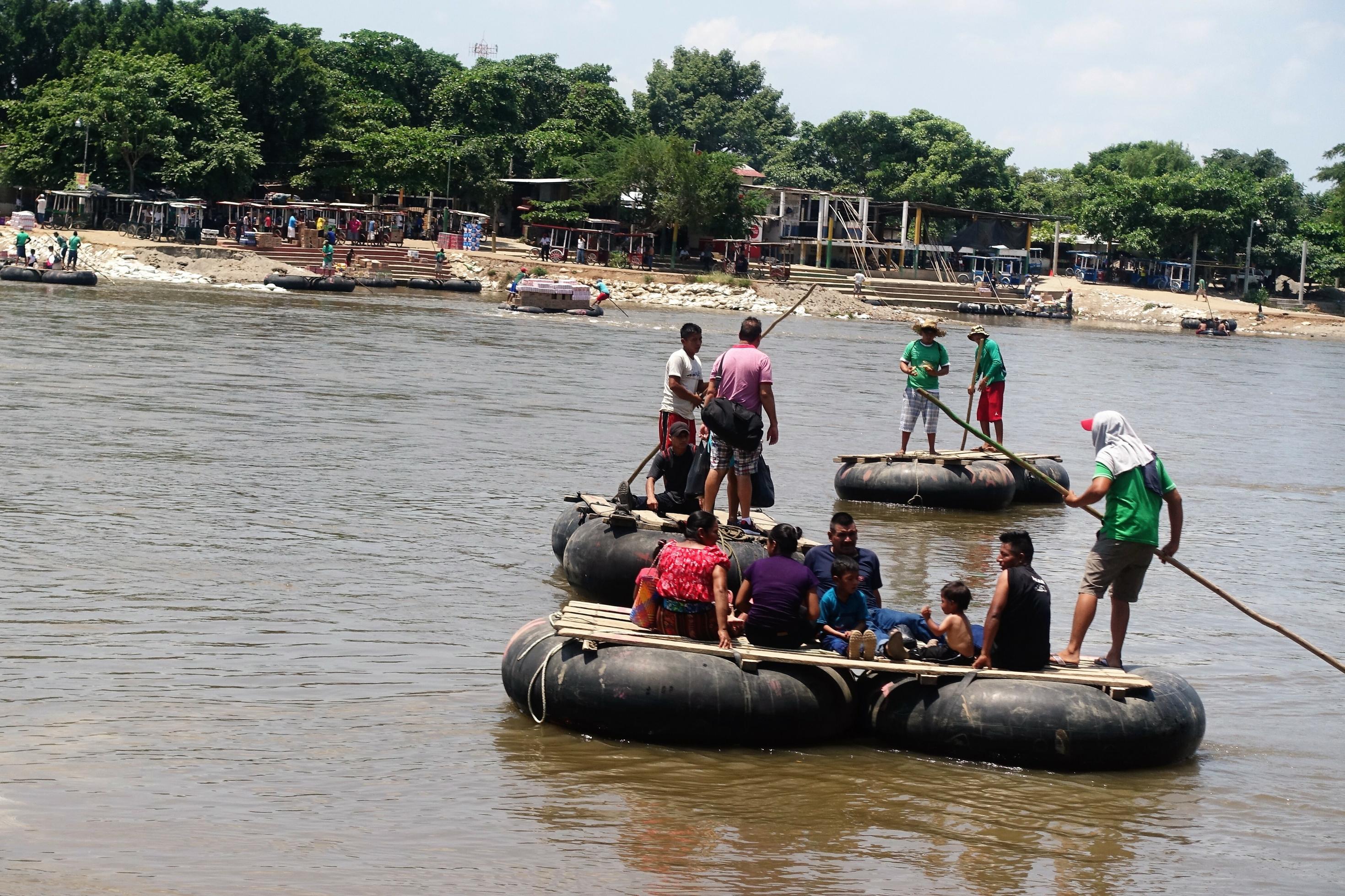 Menschen überqueren auf Schlauchbooten einen Fluss