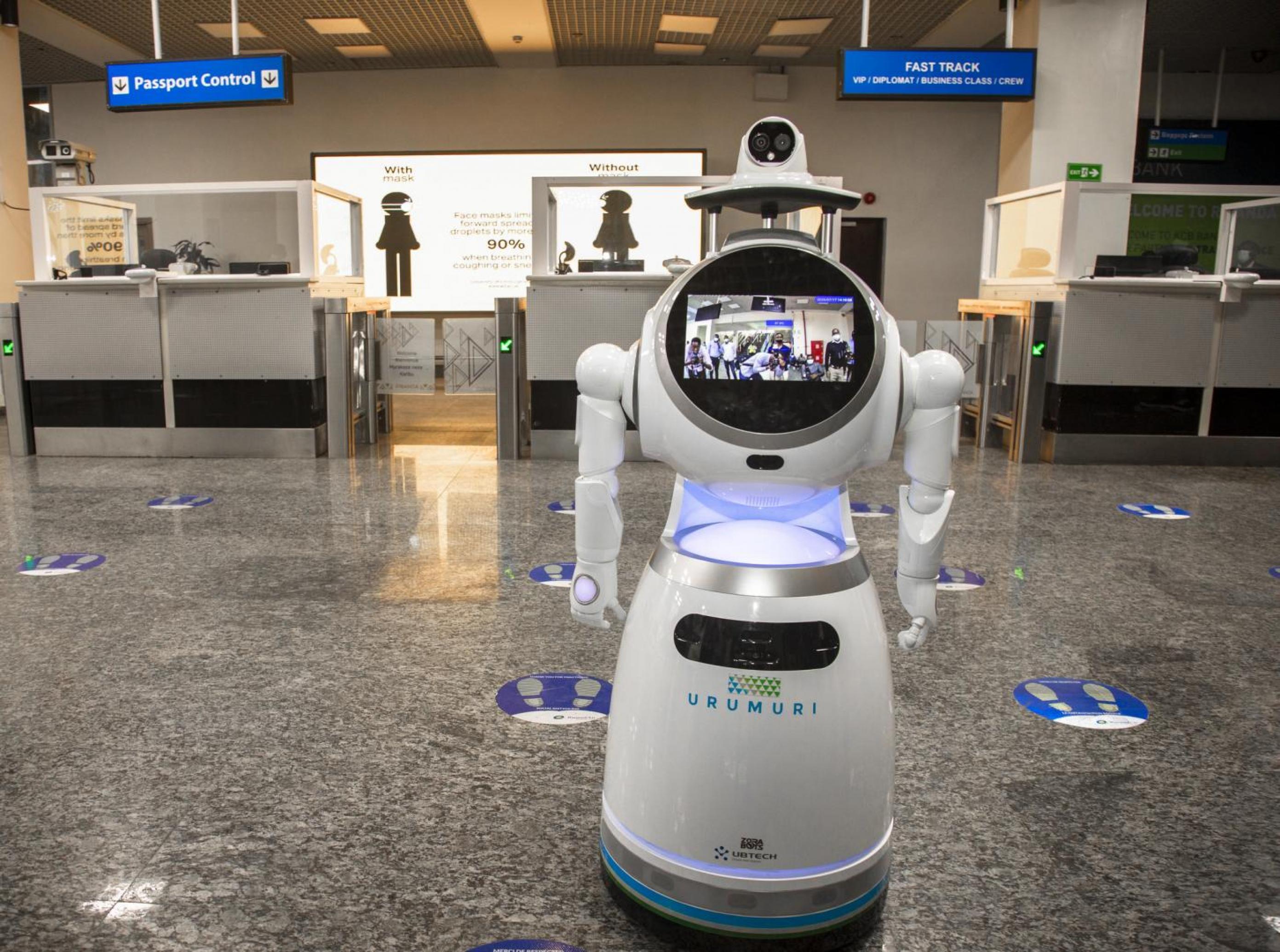Weißer Roboter mit Kamera, Bildschirm, zwei Greifarmen und der Aufschrift Urumuri im Flughafen Kigali in Ruanda.