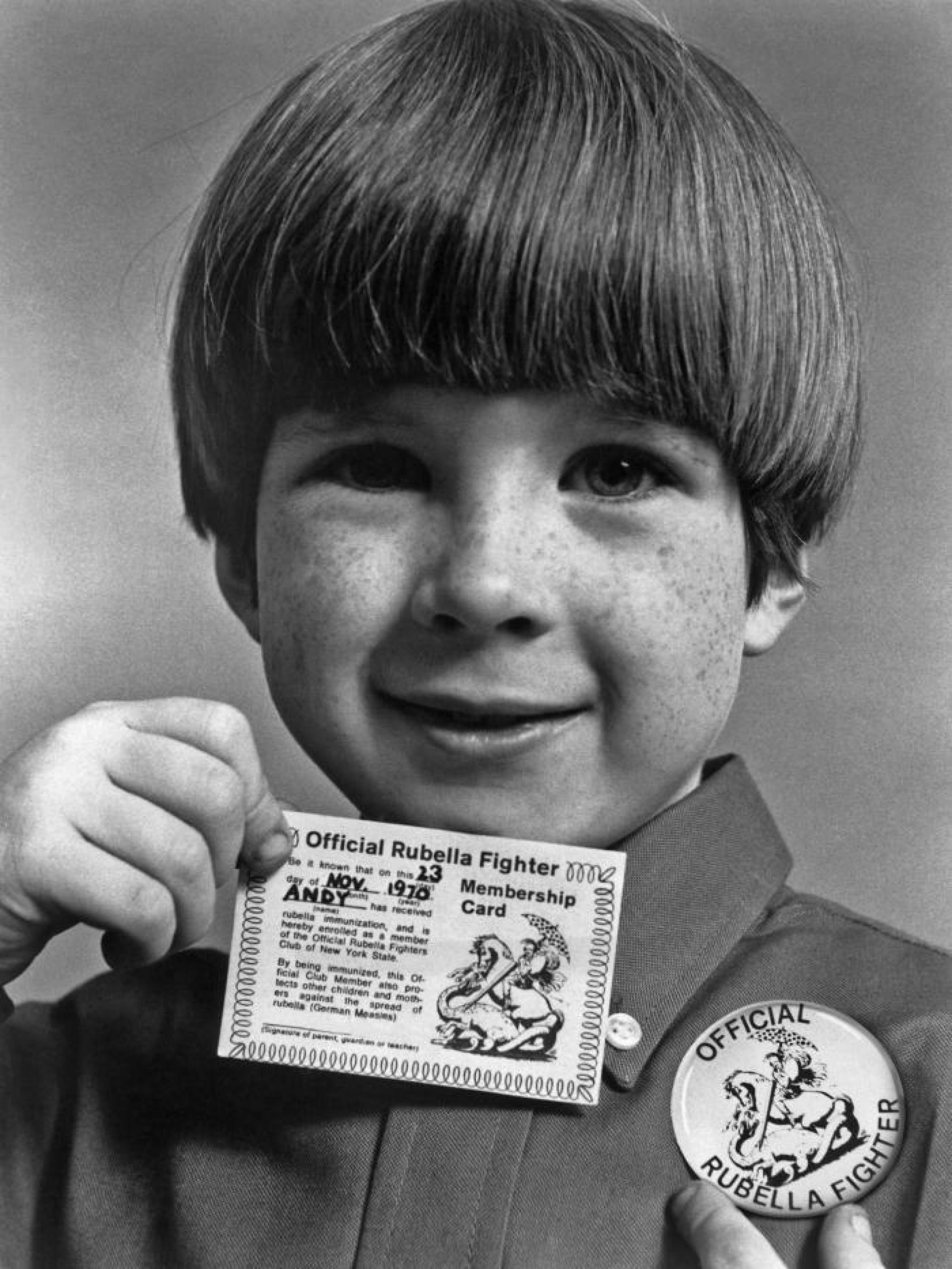 Junge, 1970 in den USA, zeigt stolz seine „Rubella Fighter Card“.