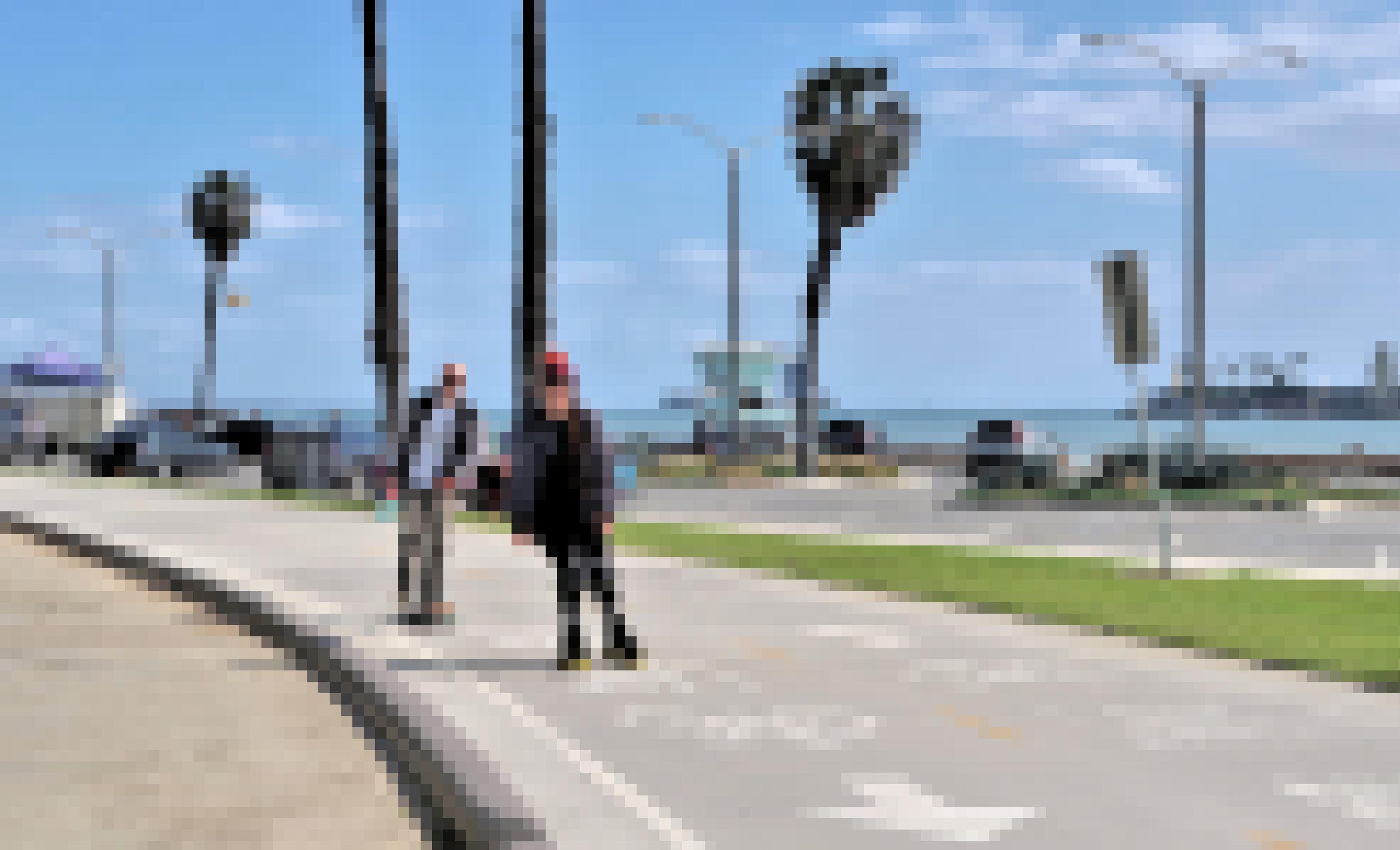 Zwei junge Leute fahren Rollschuhe am Strand von Los Angeles.