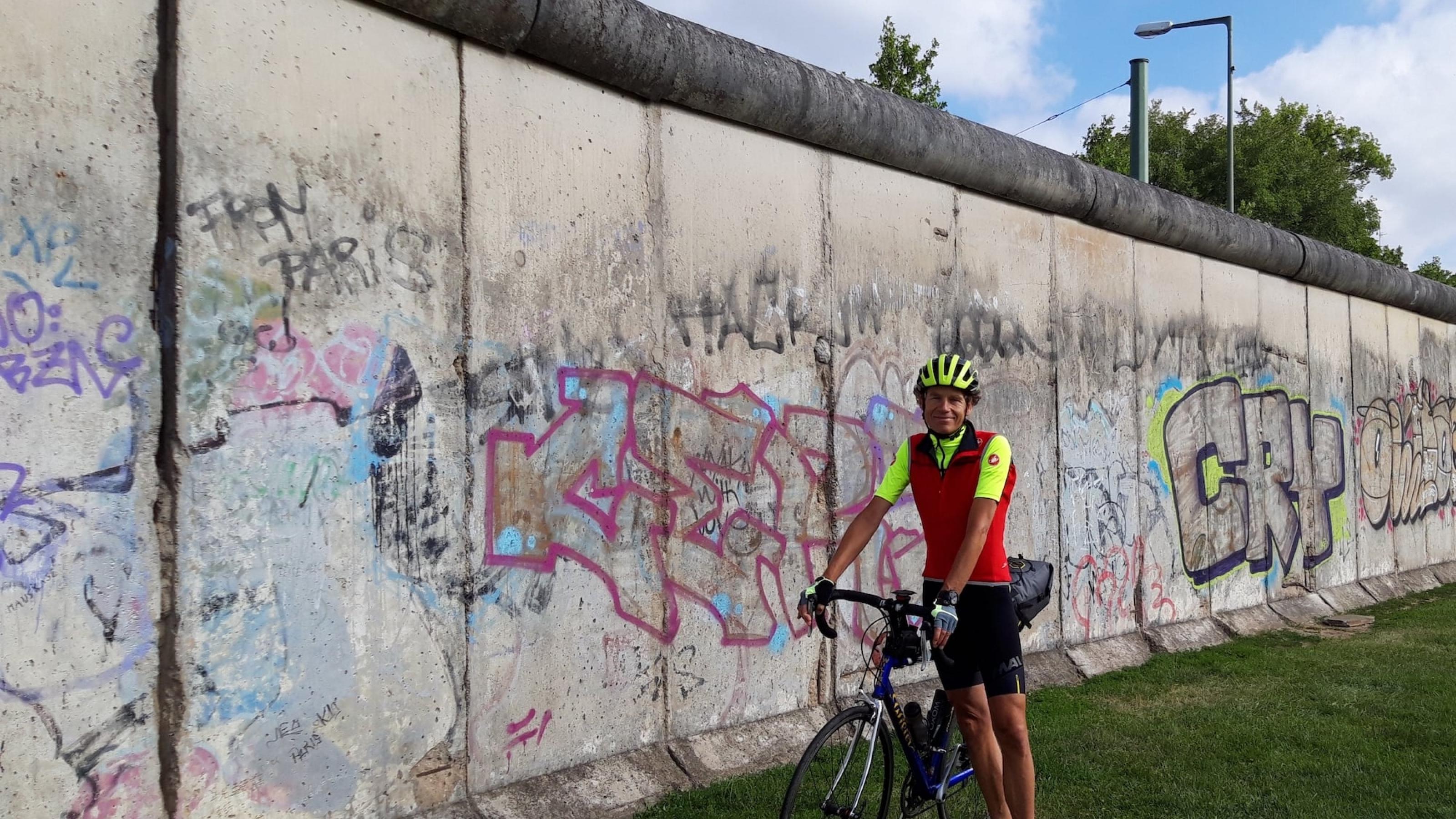 Der Radelnde Reporter Martin C. Roos in Berlin an einem Stück der Berliner Mauer.