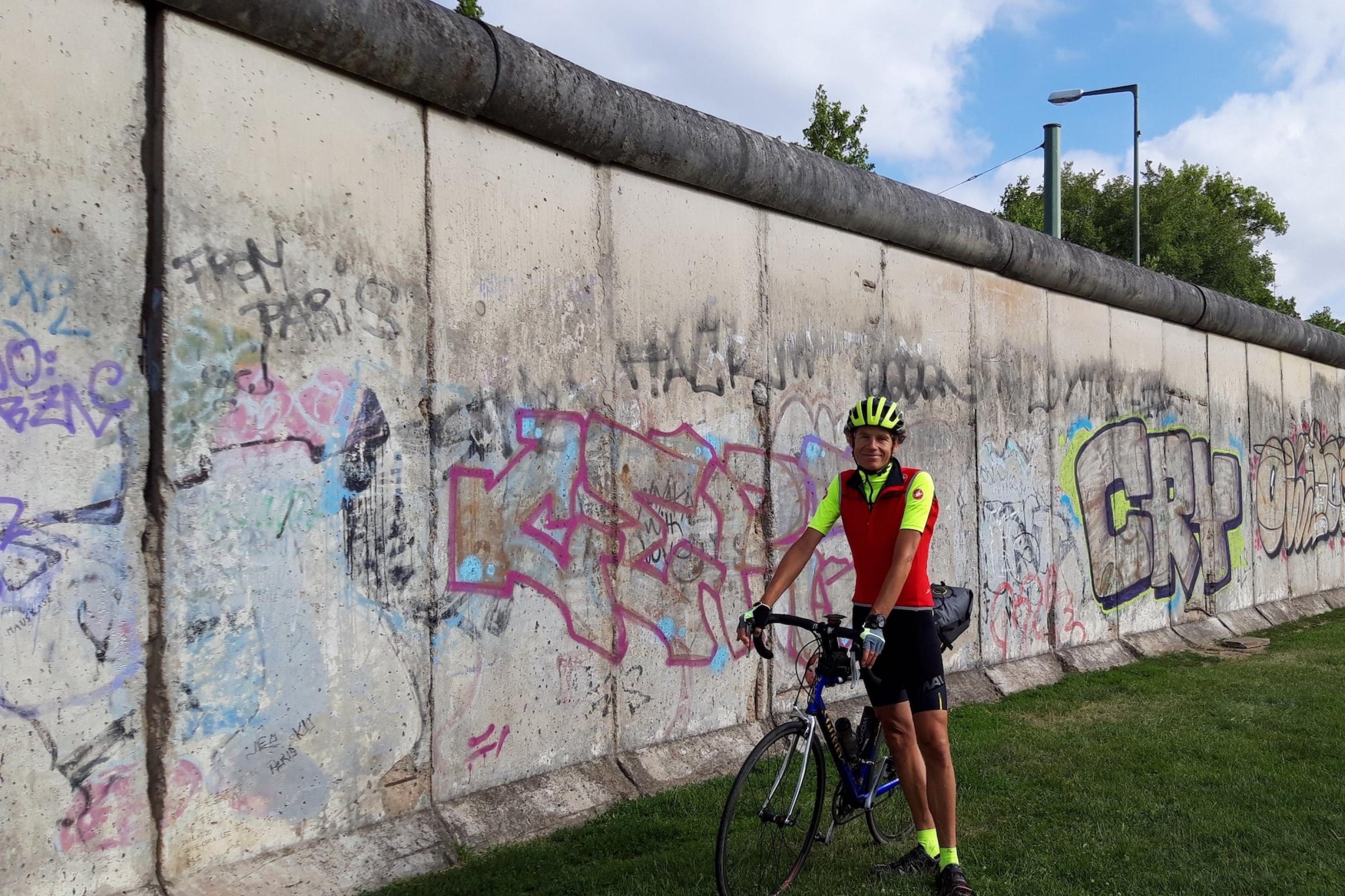 Der Radelnde Reporter Martin C. Roos in Berlin an einem Stück der Berliner Mauer.