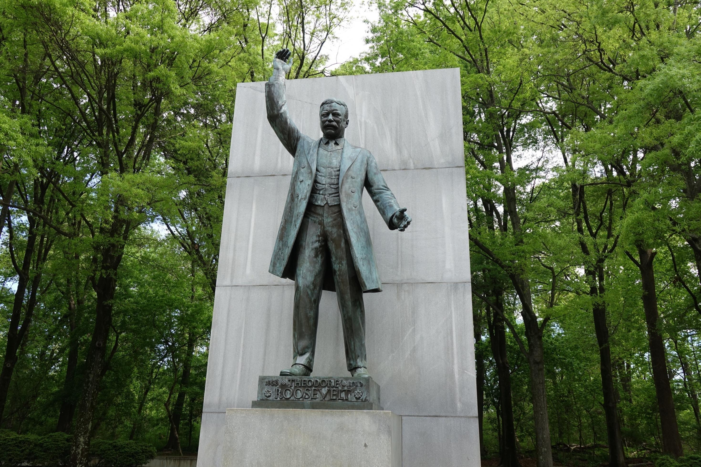 Ein Bronzedenkmal von Roosevelt mit einem erhobenen Arm.