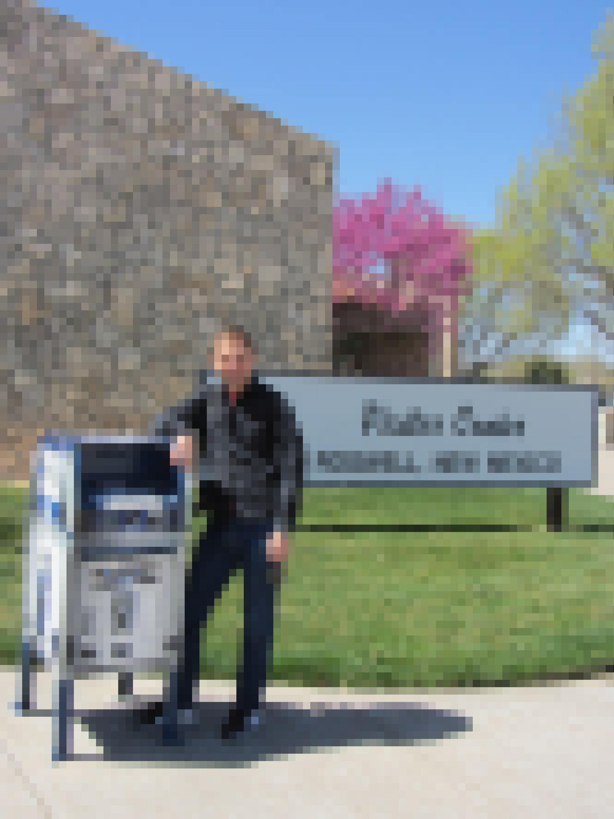 Ein junger Mann steht neben einem Briefkasten, der wie der Roboter "R2D2" aus Star Wars aussieht.