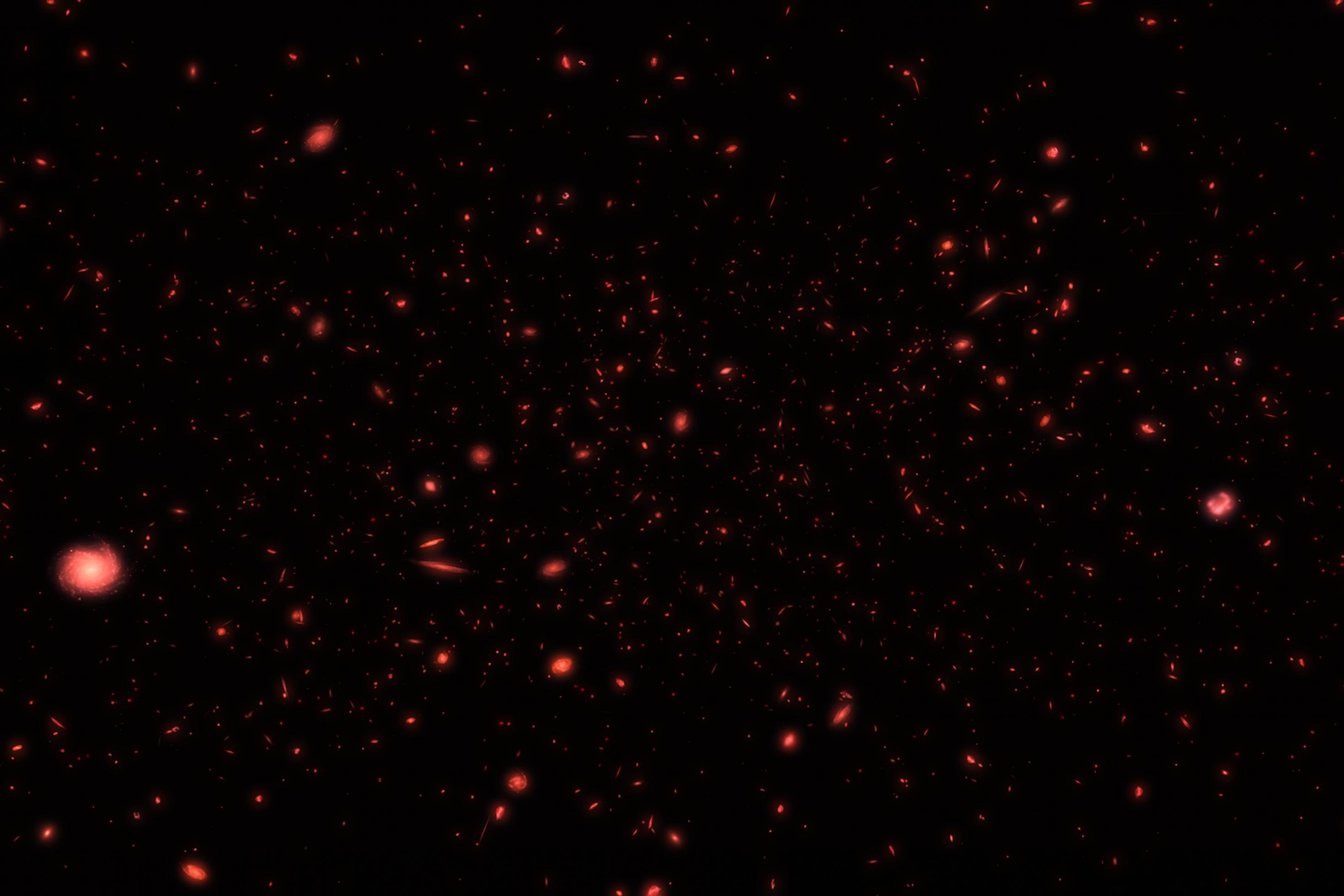 Ein Himmelsausschnitt mit schwachen, roten Galaxien