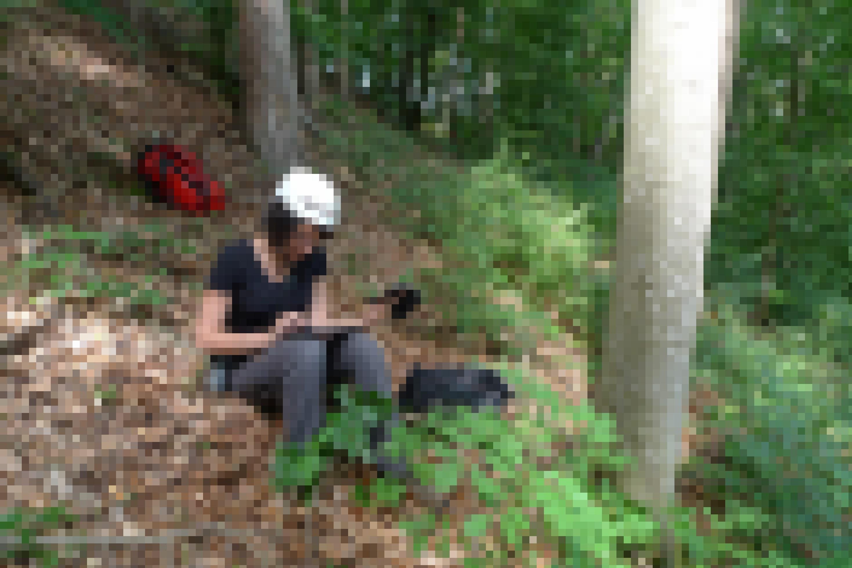 Lara Gross vom Rotmilan-Forschungsprojekt sitzt auf dem Waldboden und erfasst die Daten des jungen Rotmilans mit einem Tablet.