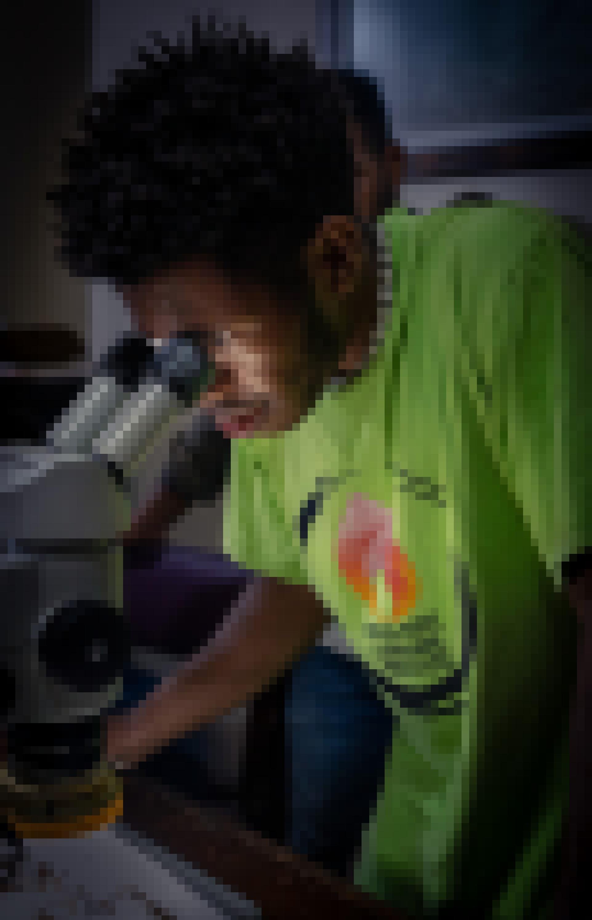 Ein Mann mit dunkler Haut schaut in eine Lichtmikroskop