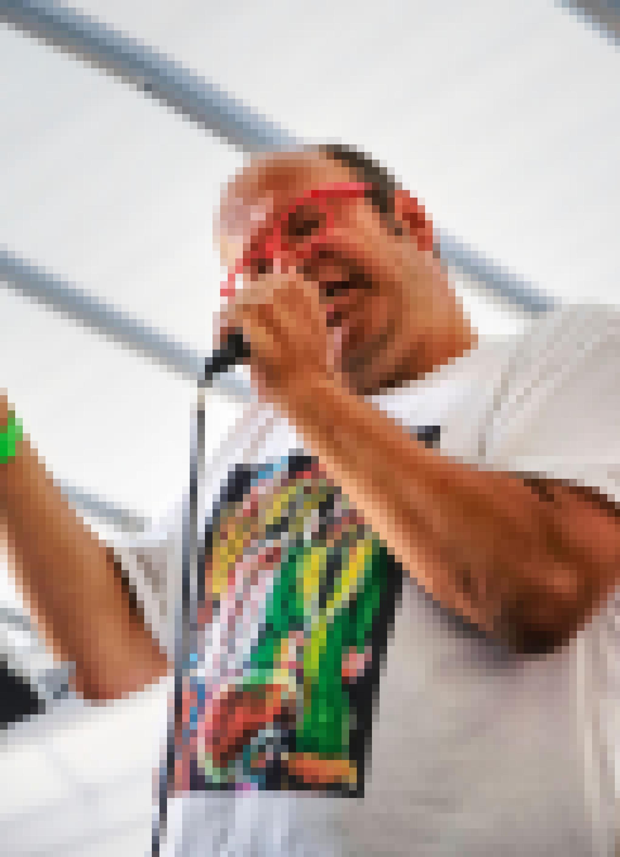 Rüdiger Bartsch am Mikrofon. Er trägt ein weißes T-Shirt mit einem bunten Aufdruck auf der Brust und eine rote Brille