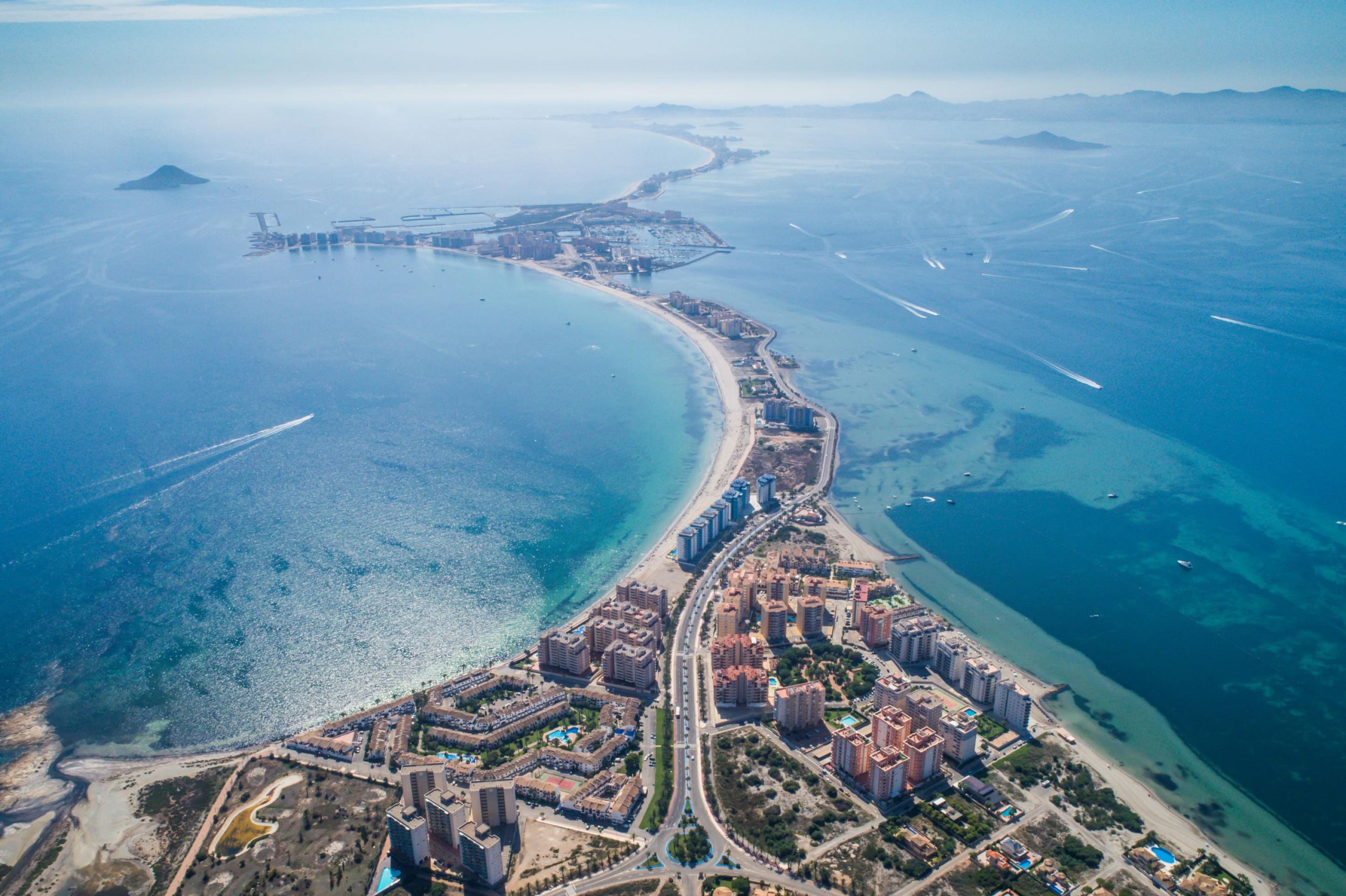 Luftaufnahme der stark bebauten Landzunge, die das die Salzwasserlagune Mar Menor vom Mittelmeer abtrennt