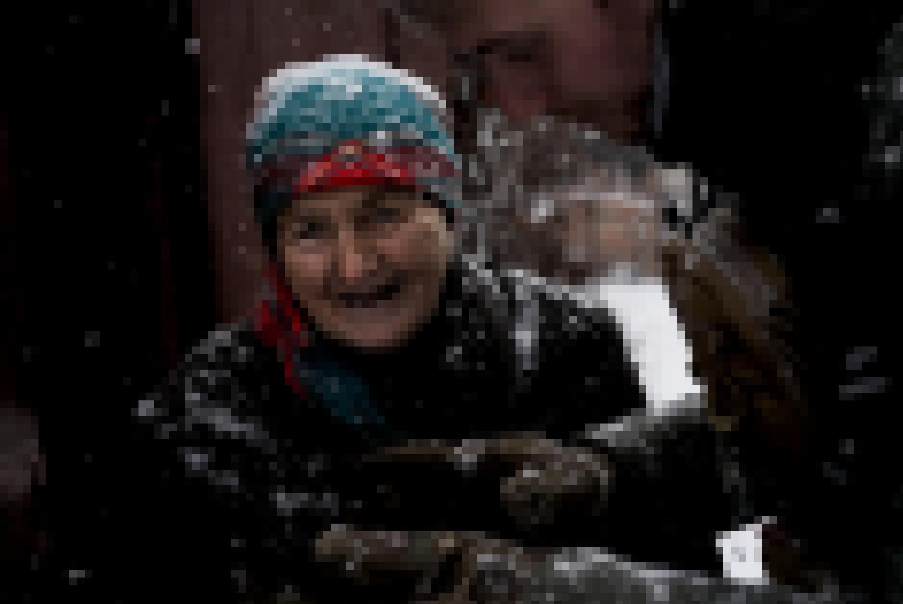 Alte ukrainische Frau lächelt bei starkem Schneefall in die Kamera.