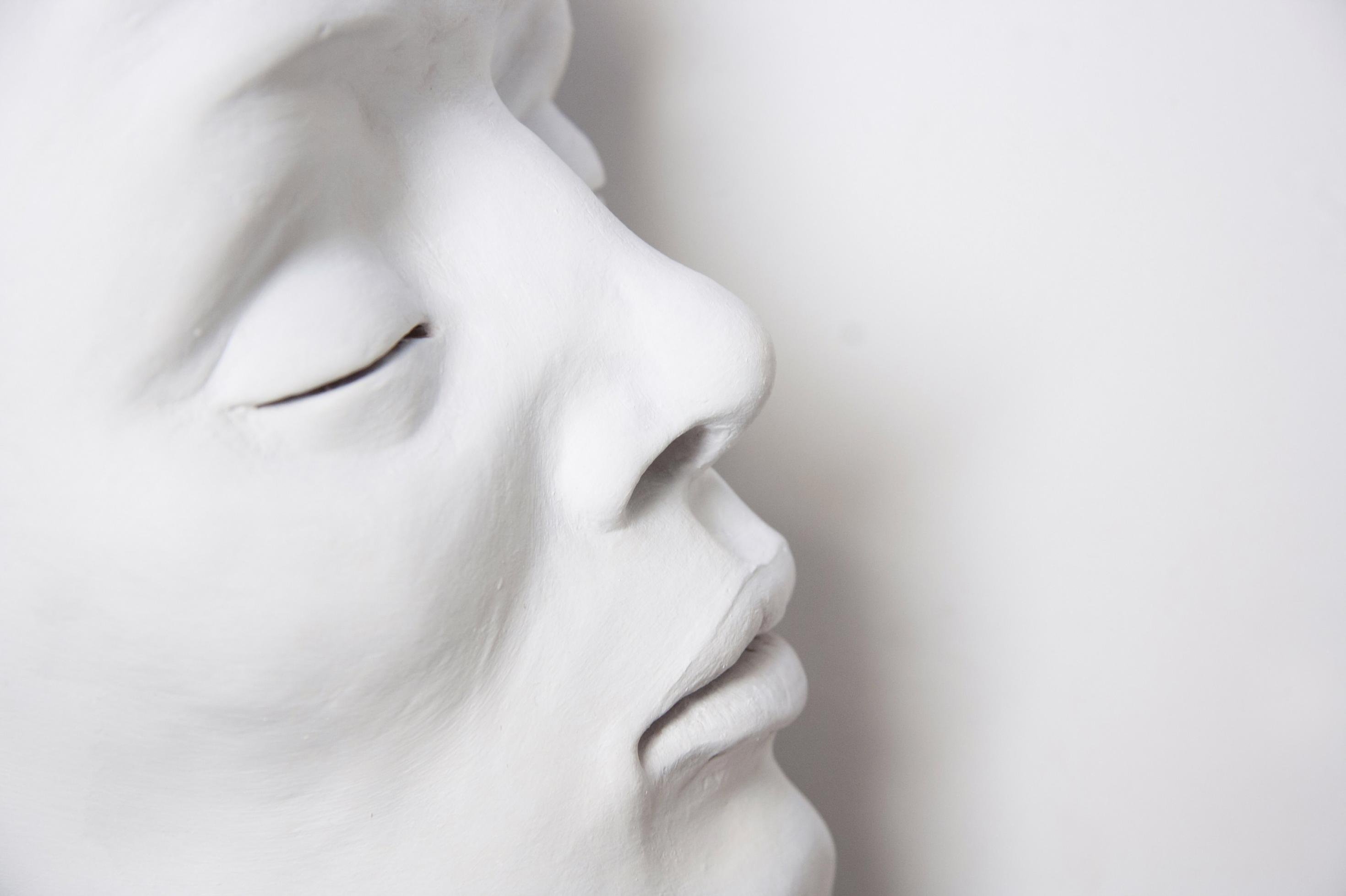 Komplett weiß geschminktes Gesicht einer schlafenden Frau mit geschlossenen Augenlidern