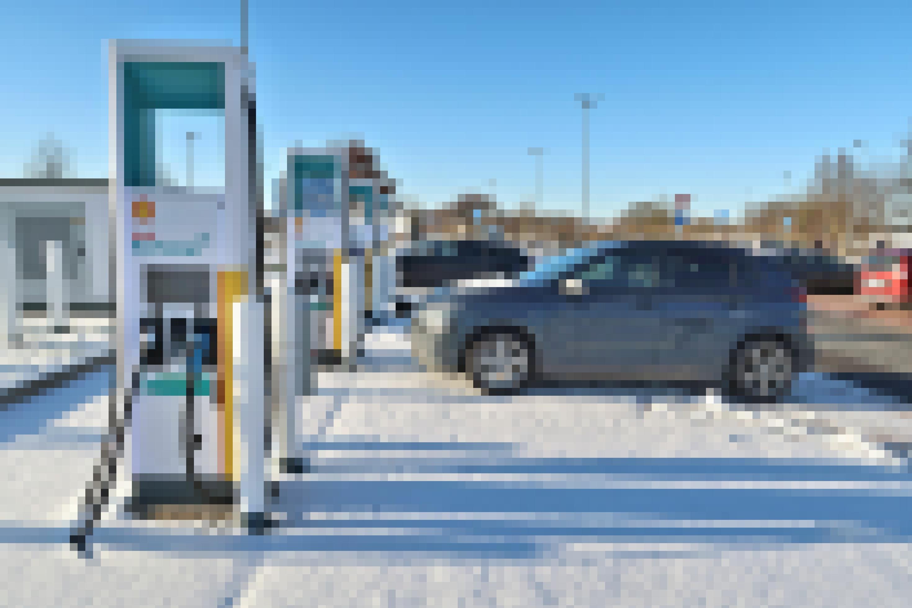 Ein Elektroauto steht vor einer Stromtankstelle im Schnee.