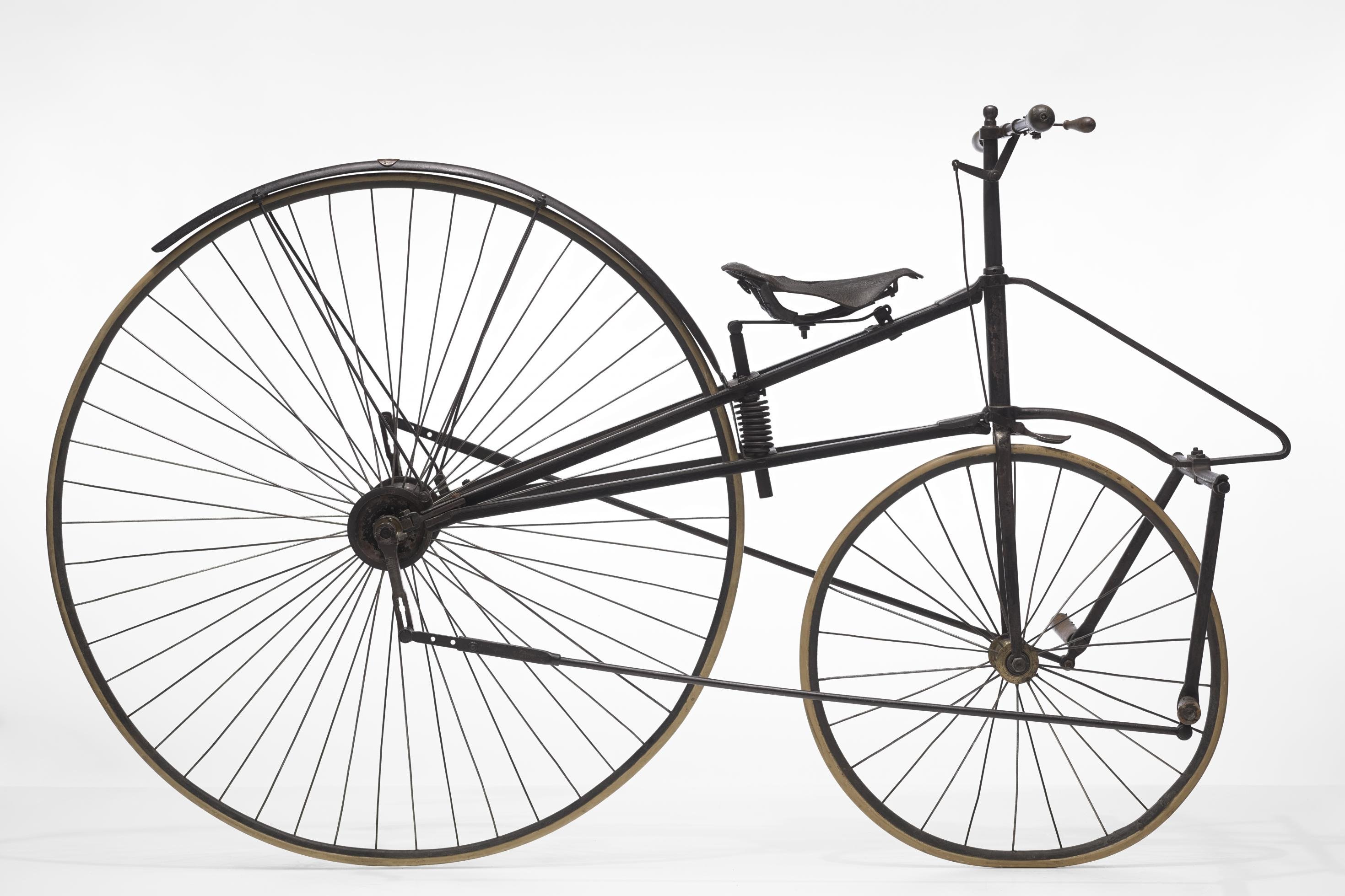 Aufnahme eines musealen Zweirads, bei dem das Hinterrad noch übermäßig groß, aber der Sattel bereits zwischen den zwei Rädern positioniert ist.