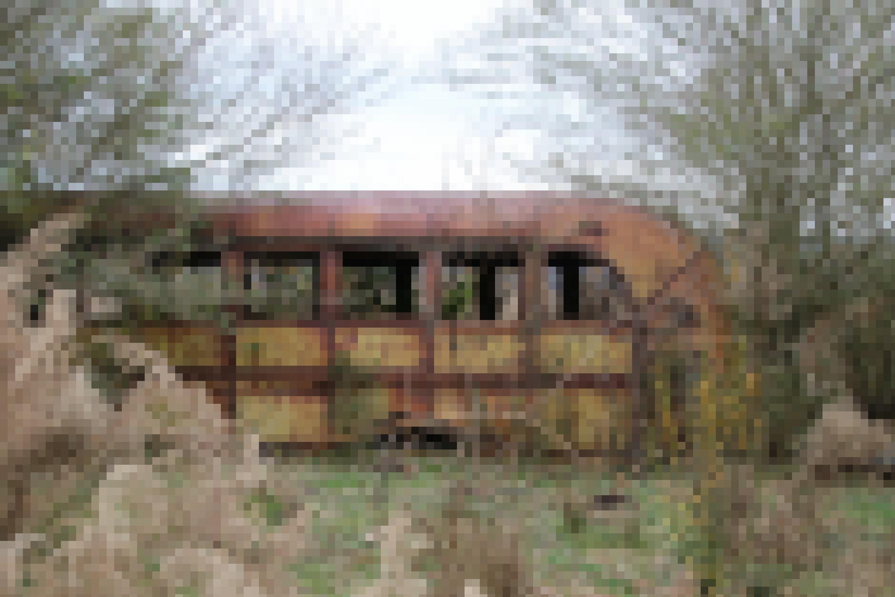 Ein verrosteter Schulbus steht in der Landschaft