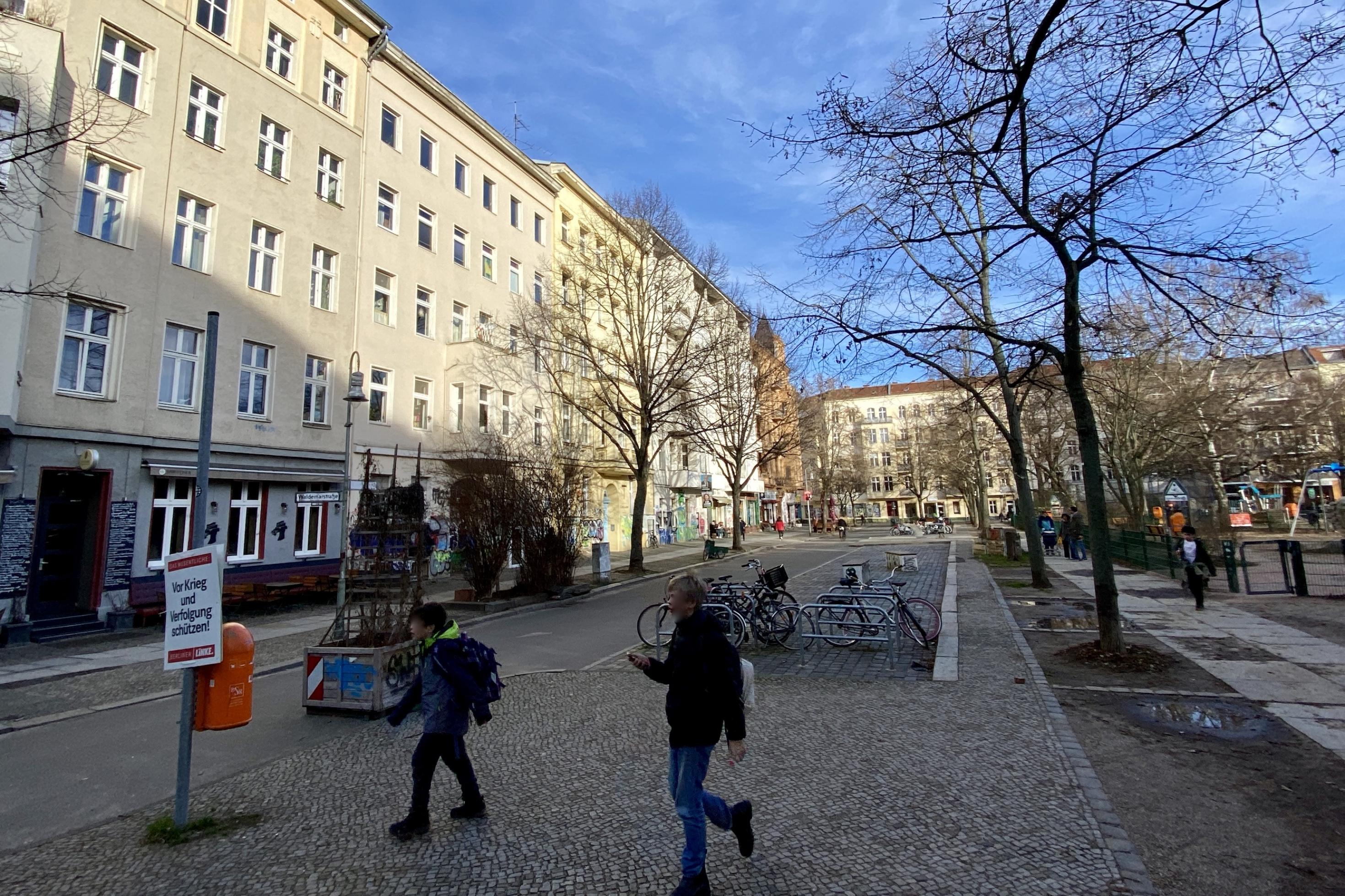 Zwei Kinder laufen über den Platz