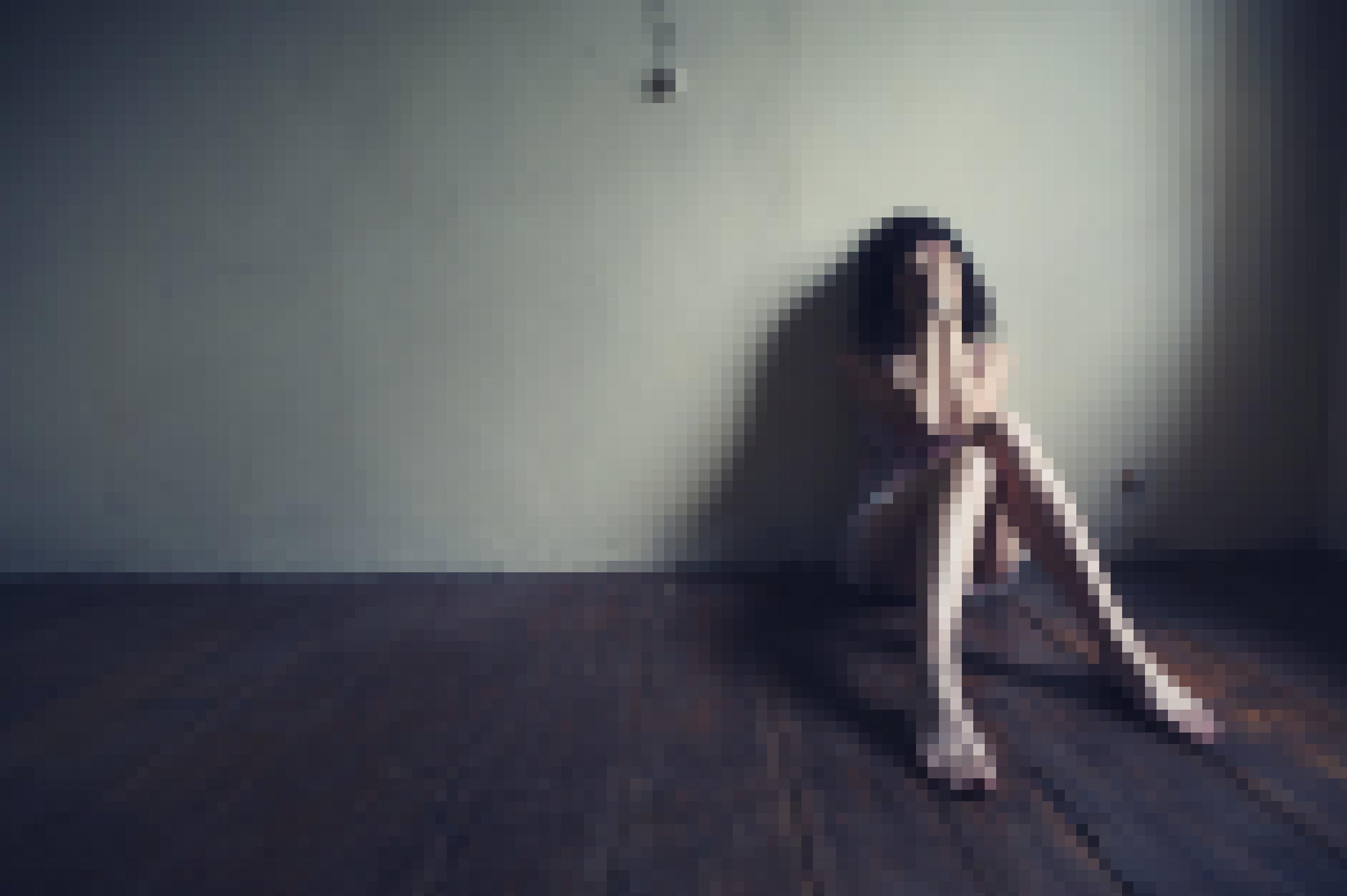 Eine traurige Frau, die alleine in einem leeren Raum auf dem Boden kauert