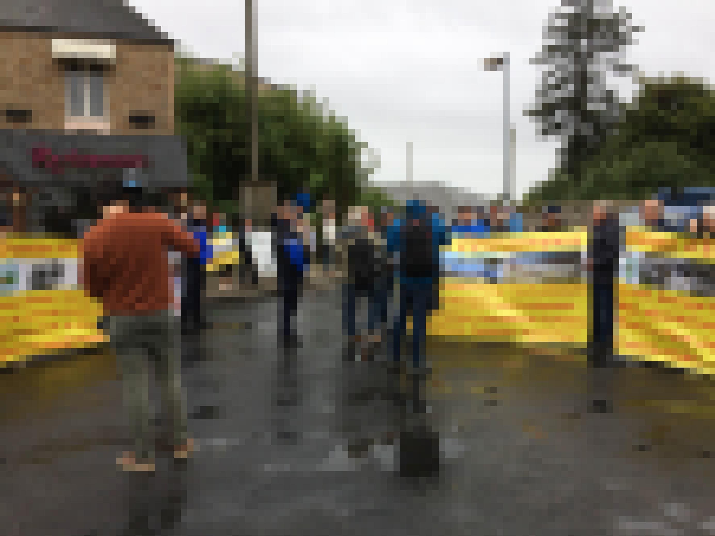 Demonstranten mit Transparenten vor einem Gemeindegebäude.