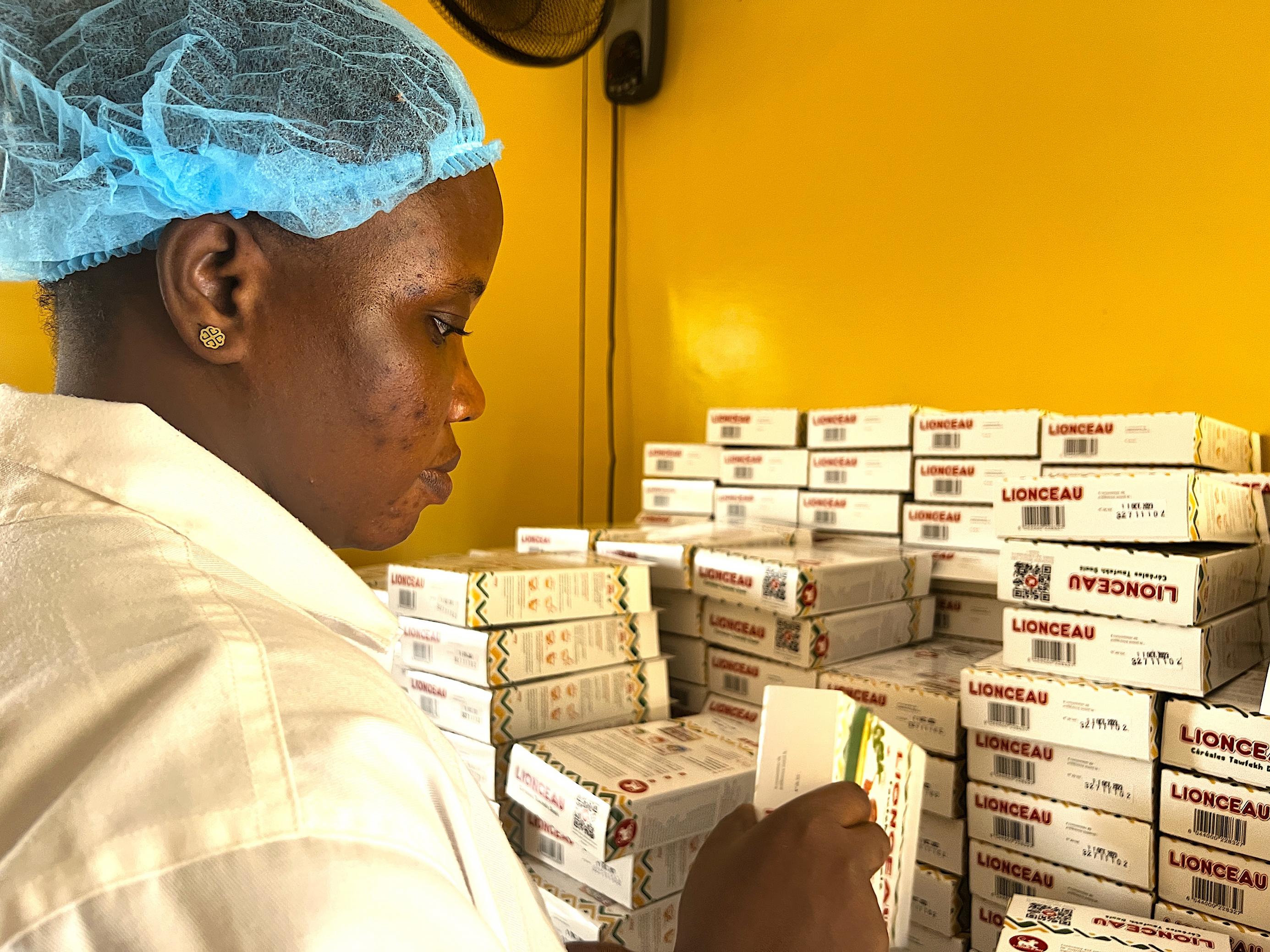 In Dakar, Senegal, etikettiert eine Mitarbeiterin des Babybreiherstellers Le Lionceau einige Schachteln mit Hirsepulver