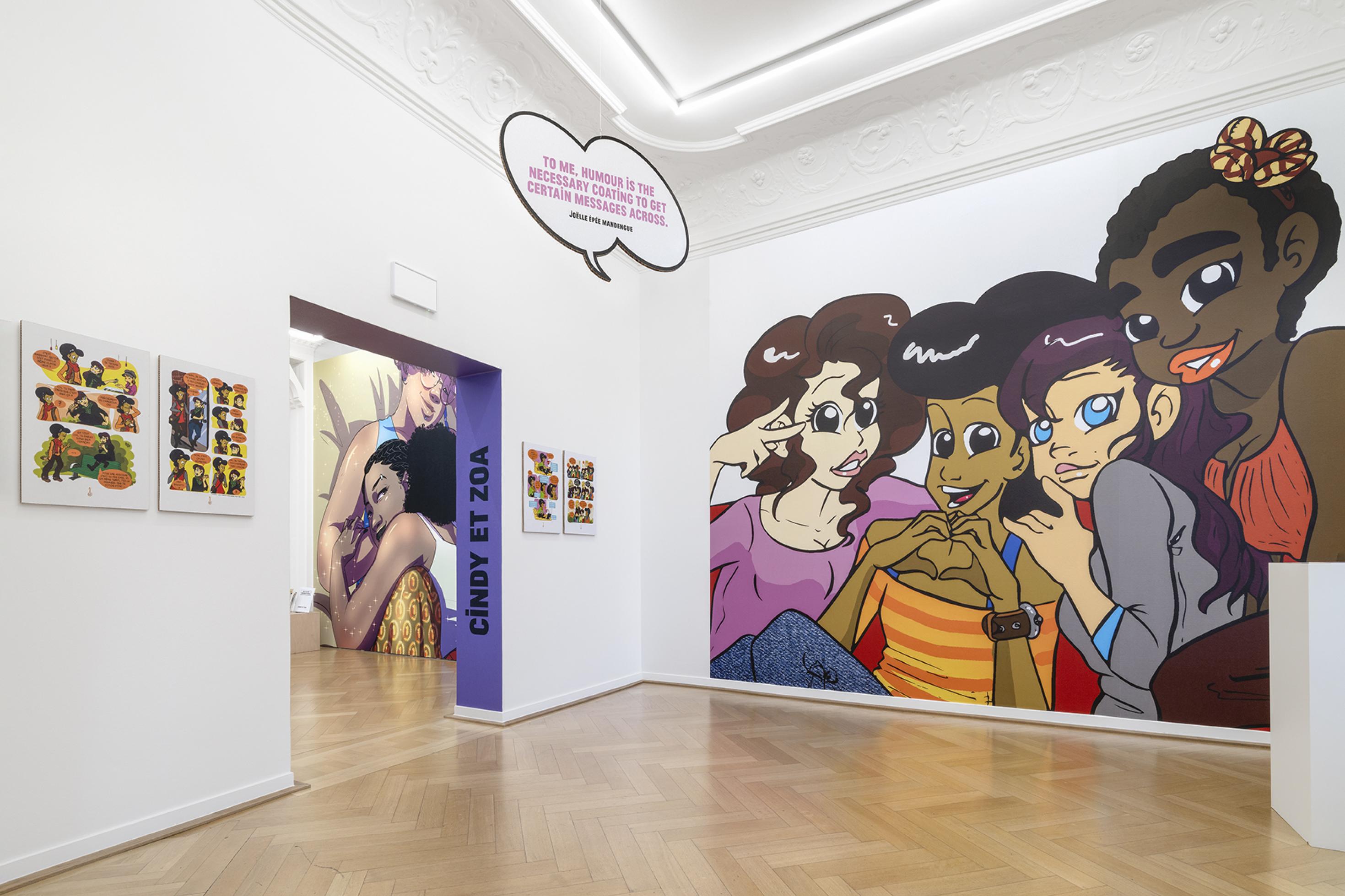 Blick in einen Ausstellungsraum: eine Comic-Zeichnung nimmt die ganze Wand ein. Sie zeigt sehr unterschiedliche Mädchen miteinander flüsternd