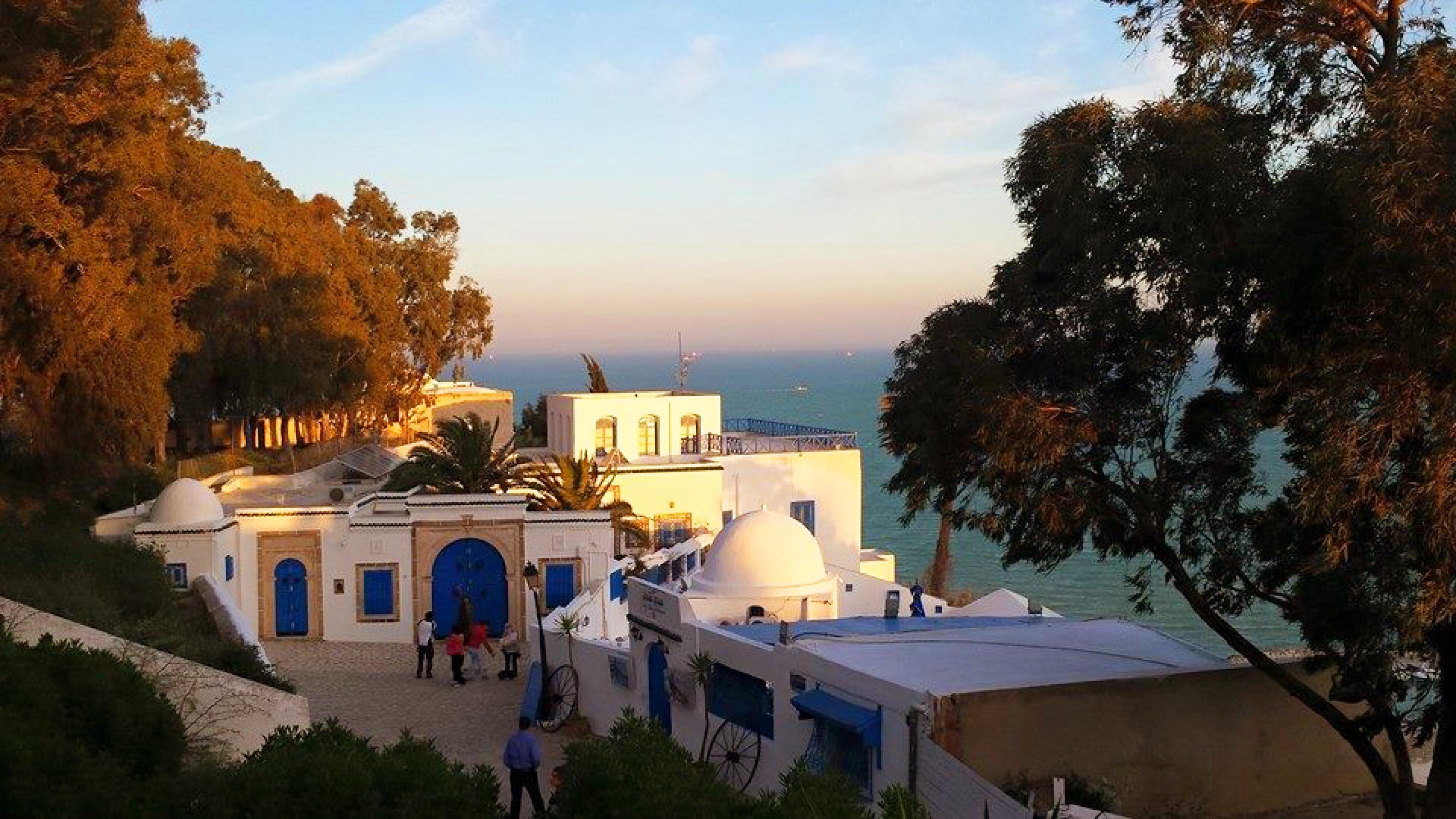 Blick auf ein Café in Sidi Bou Said, einem Vorort von Tunis, im Abendlicht, mit Blick auf das Mittelmeer im Hintergrund