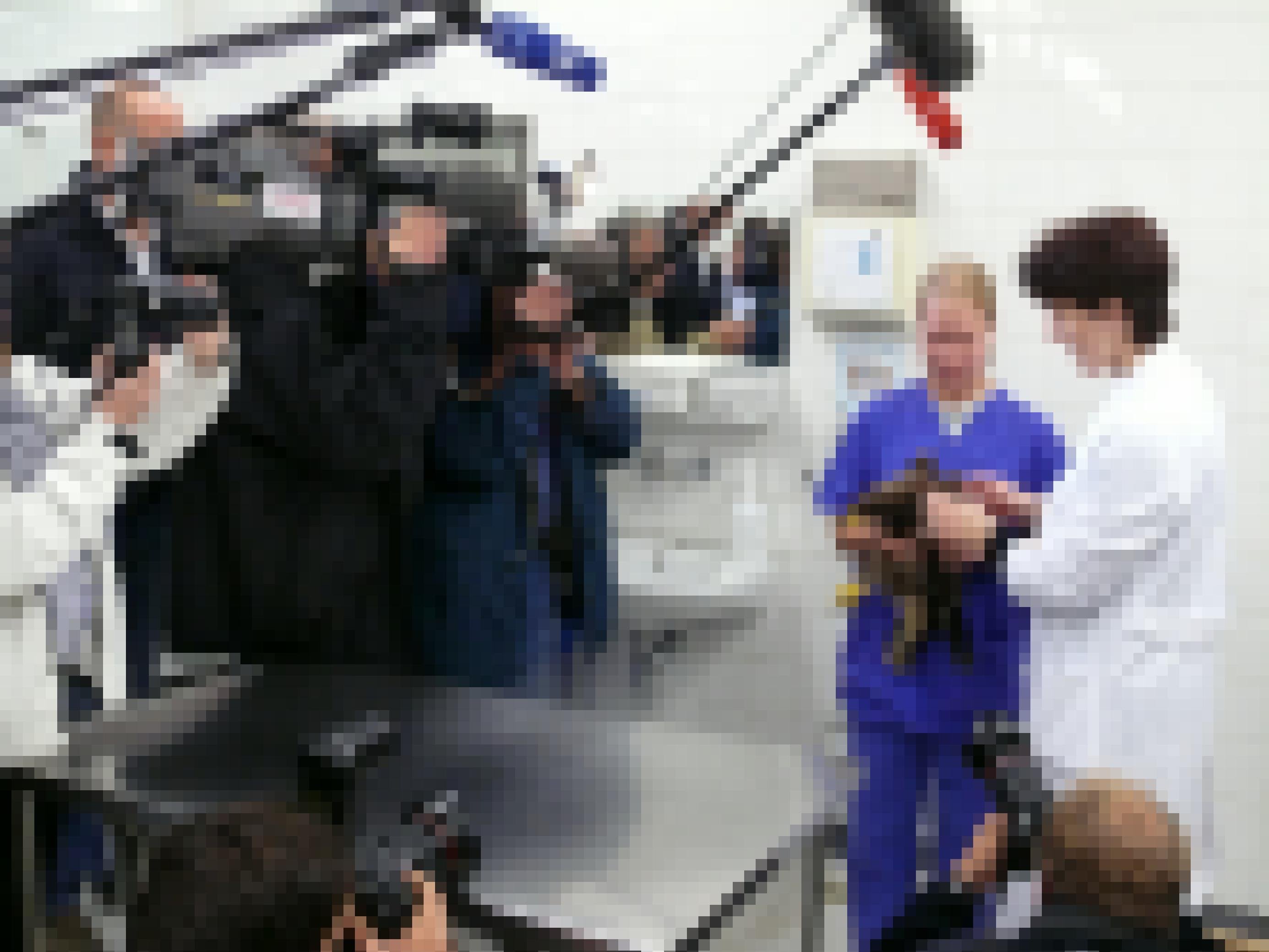 Viele Fotografen um den Adler herum, der von einem Tierarzt in einem weißen Kittel gehalten wird.