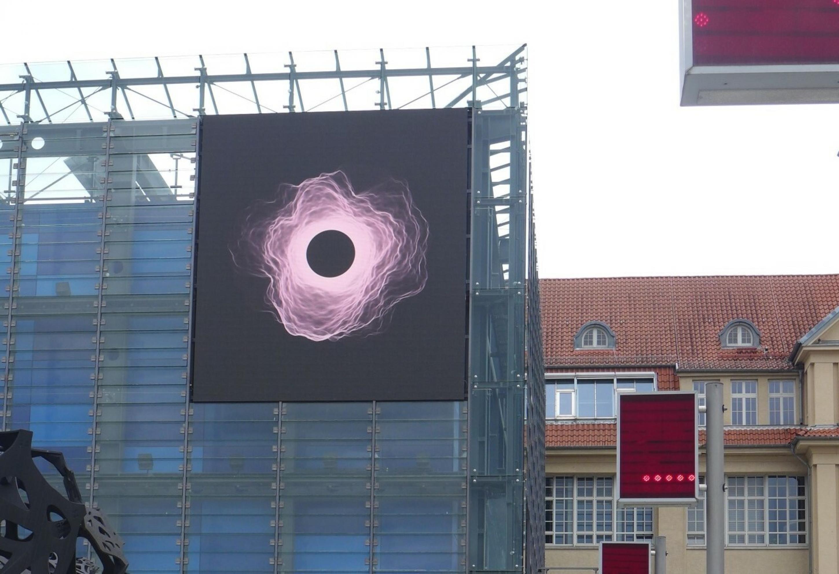 Eine LED-Wand, die einen schwarzen Kreis mit einer Corona zeigt, wie sie bei der Sonnenfinsternis vorkommt.