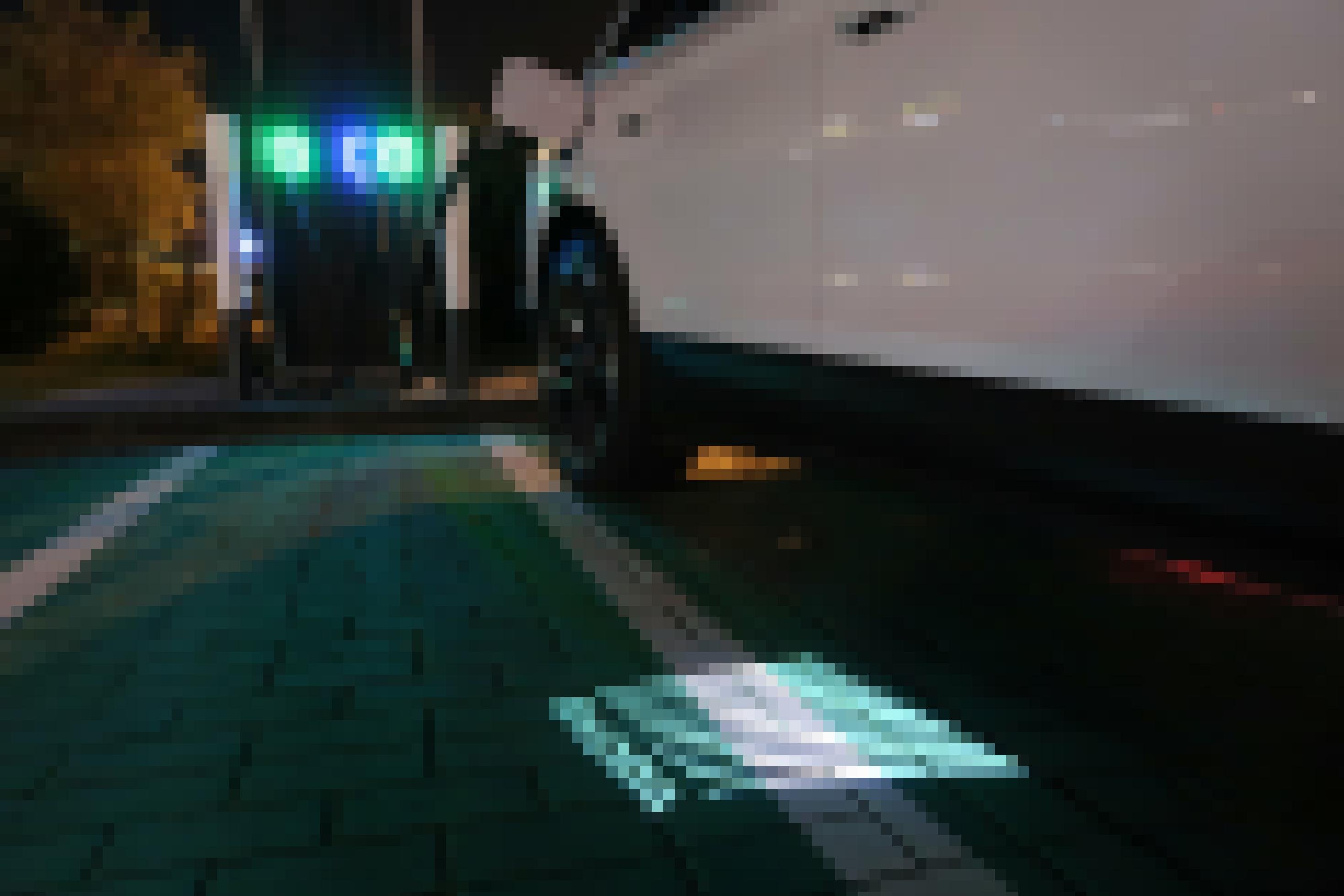 Ein Elektroauto lädt im Dunkeln strom. Auf dem Boden ist ein leuchtendes Skoda-Logo zu sehen.