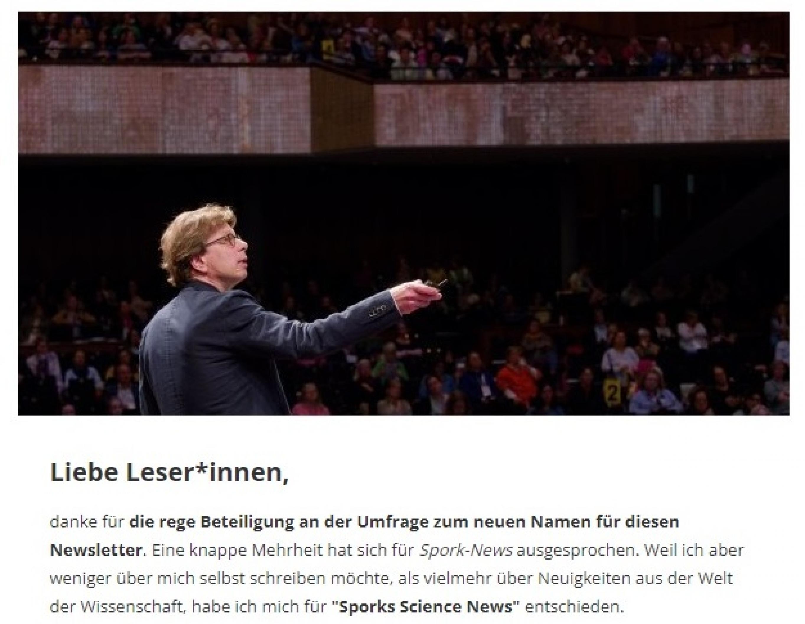 Ein Redner steht vor großem Publikum. Darunter beginnt ein Brief mit den Worten „Liebe Leser*innen“.