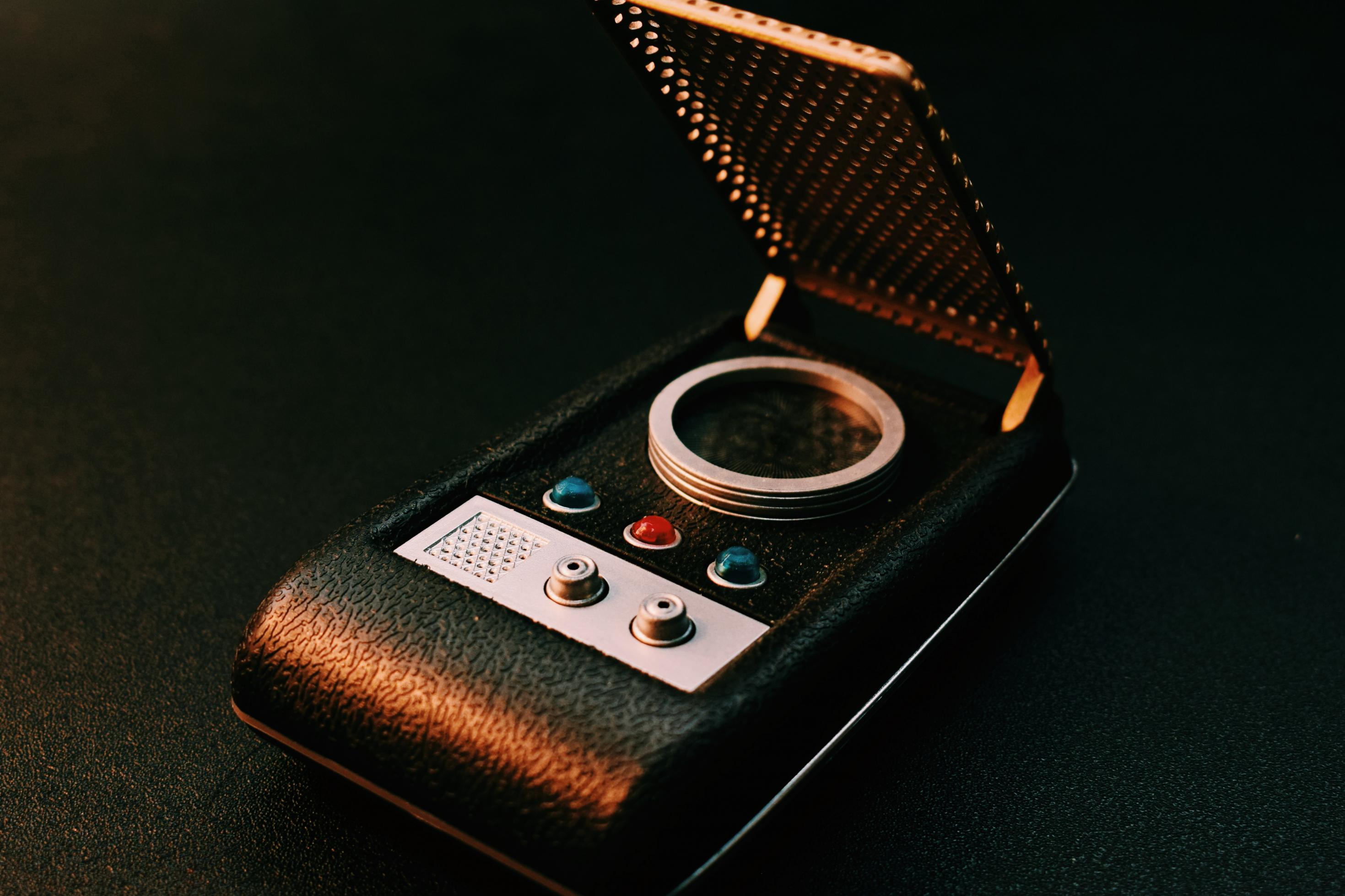 Ein Kommunikator aus der Science-Fiction-Serie Star Trek aus den 1960er Jahren. Damals nicht mehr als ein schwarzes Stück Kunststoff mit einer goldenen Gitter-Abdeckung, kleinen Knöpfen und blinkenden Lichtern, so war es doch die Vorlage für das erste Klapphandy von Motorola.
