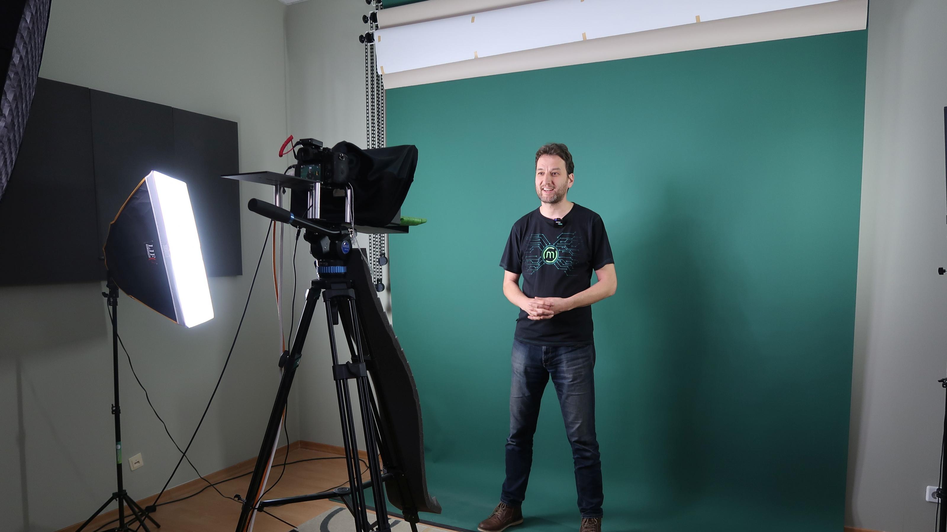 Stefan Moeller steht vor einer grünen Leinwand und wird gefilmt.