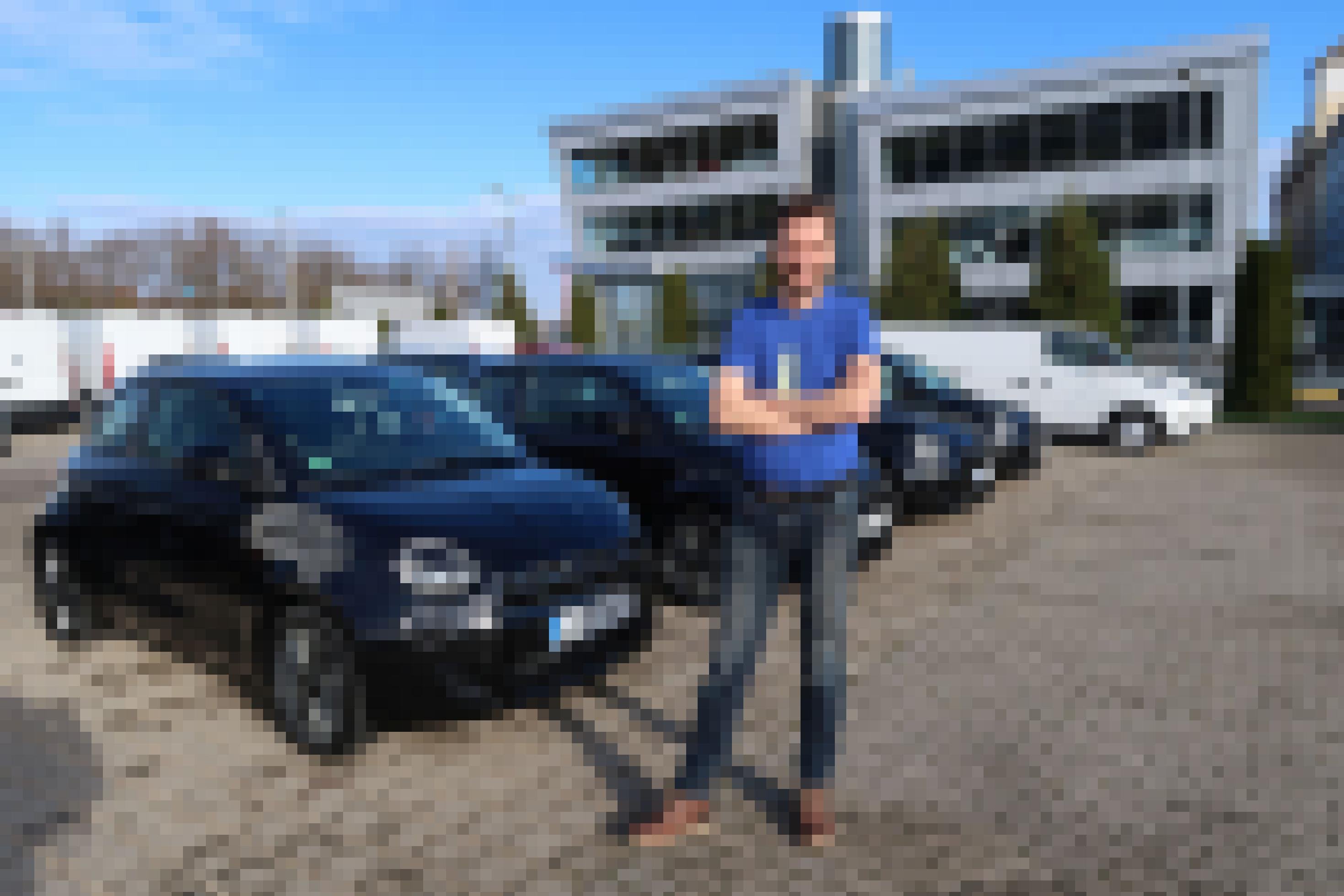 Stefan Moeller steht auf dem Hof seiner Autovermietung zwischen Elektroautos.