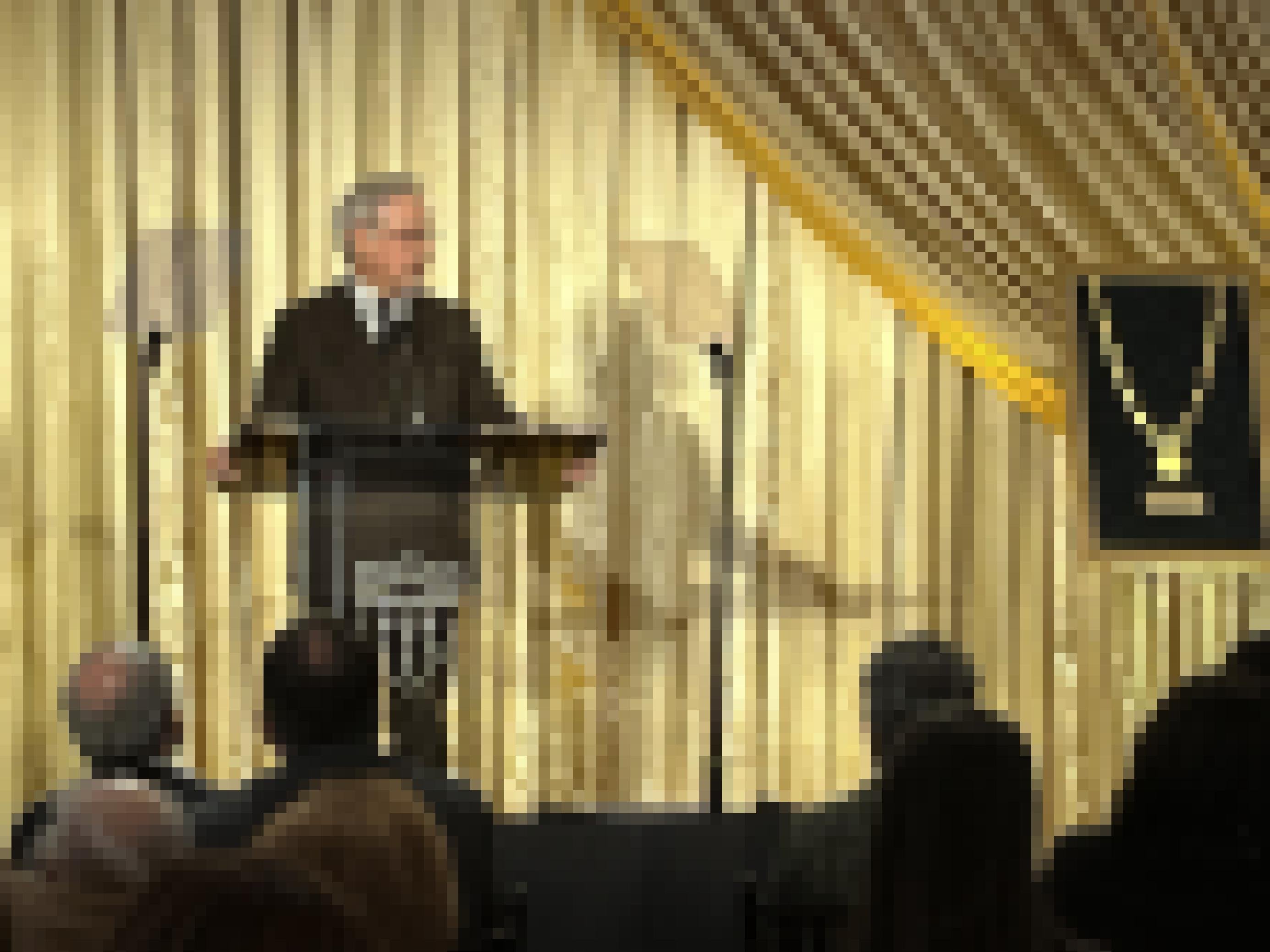 Regisseur Steven Spielberg steht auf einer Bühne vor einem goldenen Vorhang am Rednerpult.