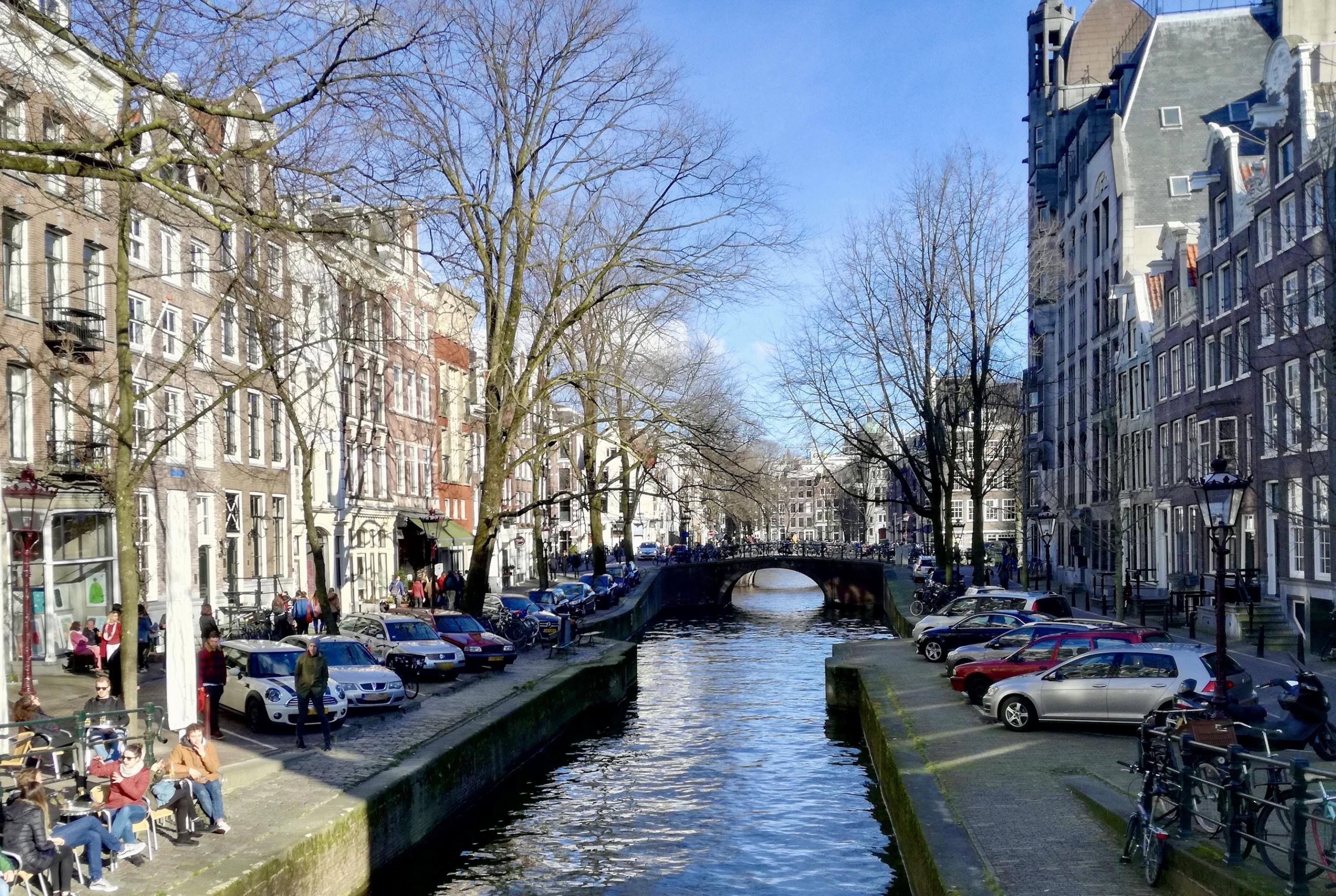 Rechts und links von der Gracht parken Autos