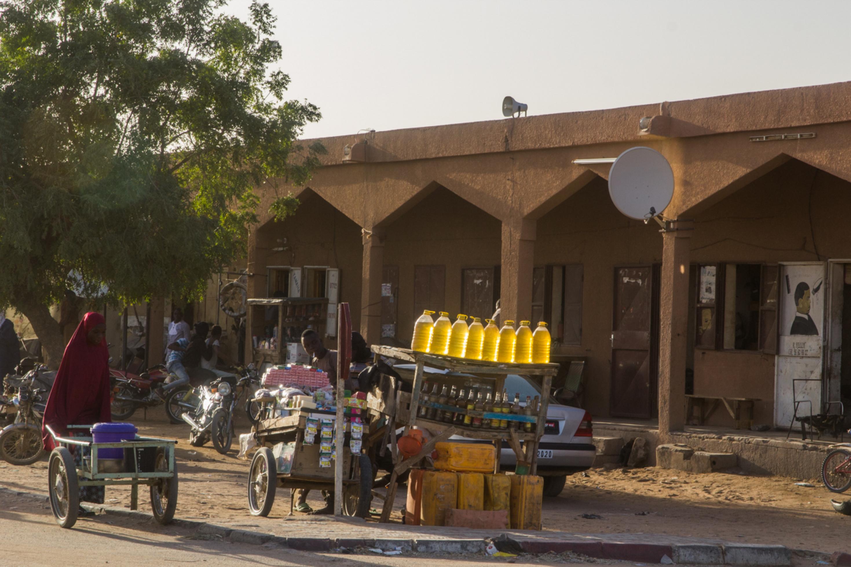 Straßenszene in Agadez im Norden der Republik Niger. Viele Waren werden an fliegenden Ständen verkauft, so wie Benzin, das hier in Flaschen angeboten wird.